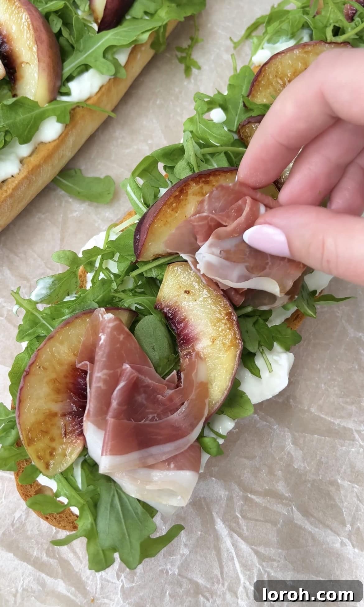 adding parma ham. Slices of delicate Parma ham artfully placed on top of the rocket and burrata, ready to complement the peaches.