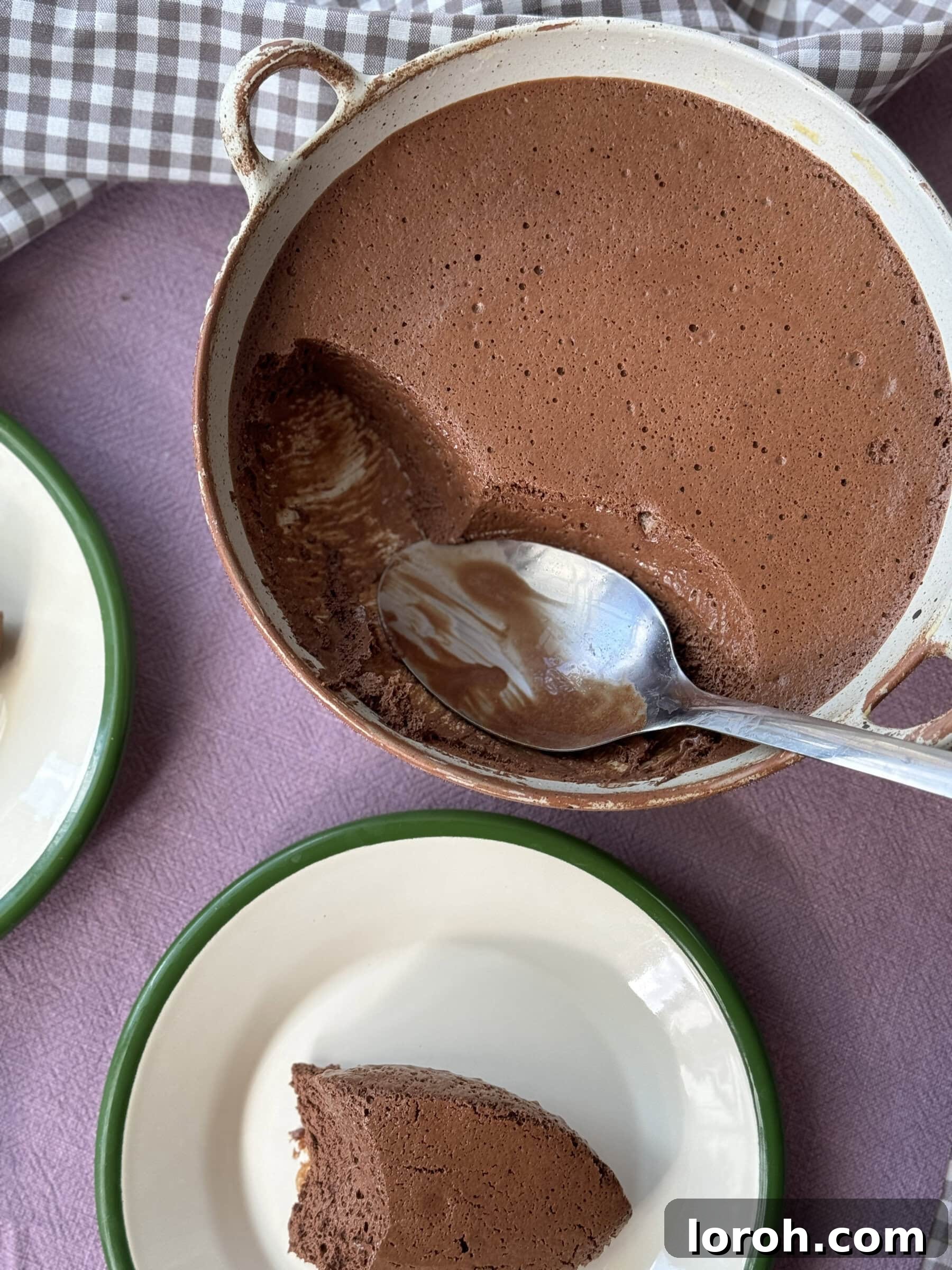 A spoon dipping into creamy Mousse Au Chocolat, highlighting its perfect texture.