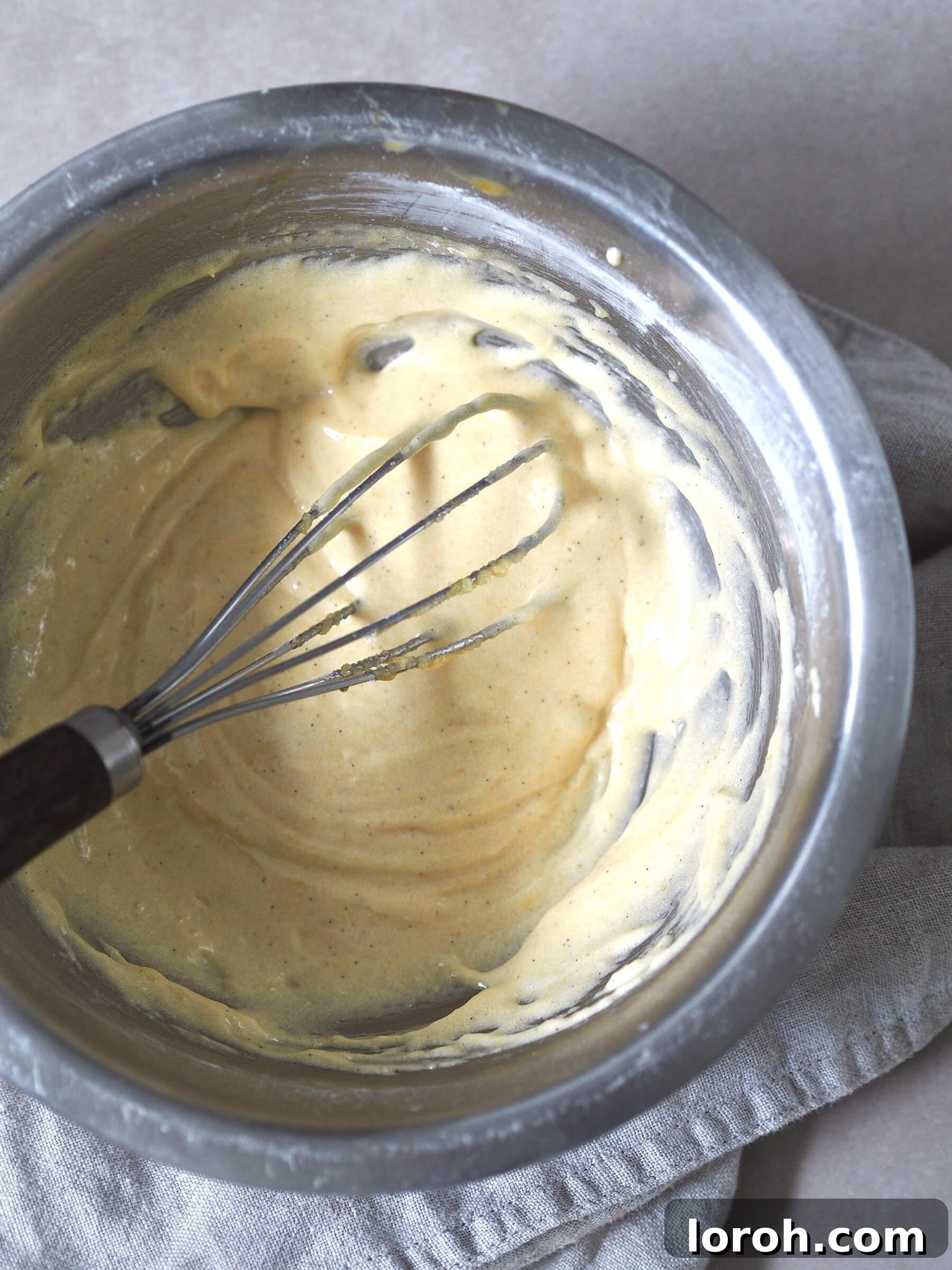 Classic Sprinkle Sponge with Golden Custard 6 Cake batter ingredients being expertly whisked together in a gleaming metal bowl, creating a smooth and creamy mixture for the sponge cake.