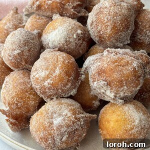 A bowl of Sfingi doughnuts, coated in sugar, ready to be served.