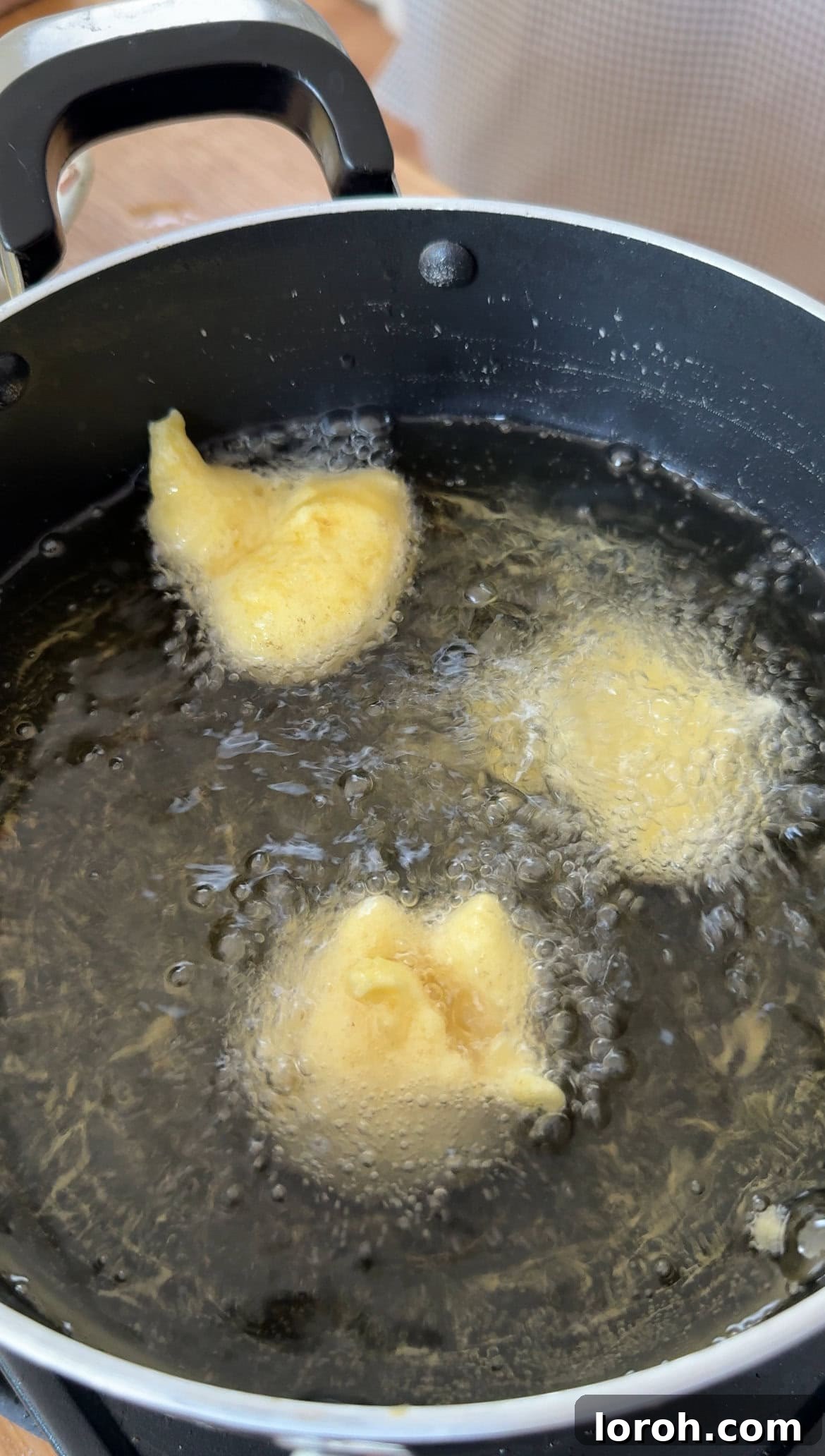Pillowy Italian Sfingi Doughnuts 7 Sfingi frying in hot oil, beginning to puff up and turn golden brown.