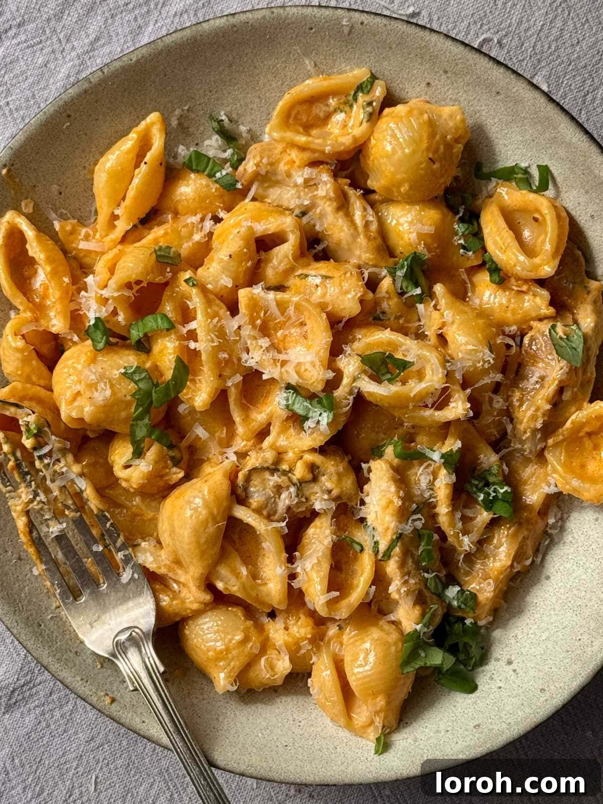 Bowl of creamy chicken garlic parmesan pasta with fresh basil.