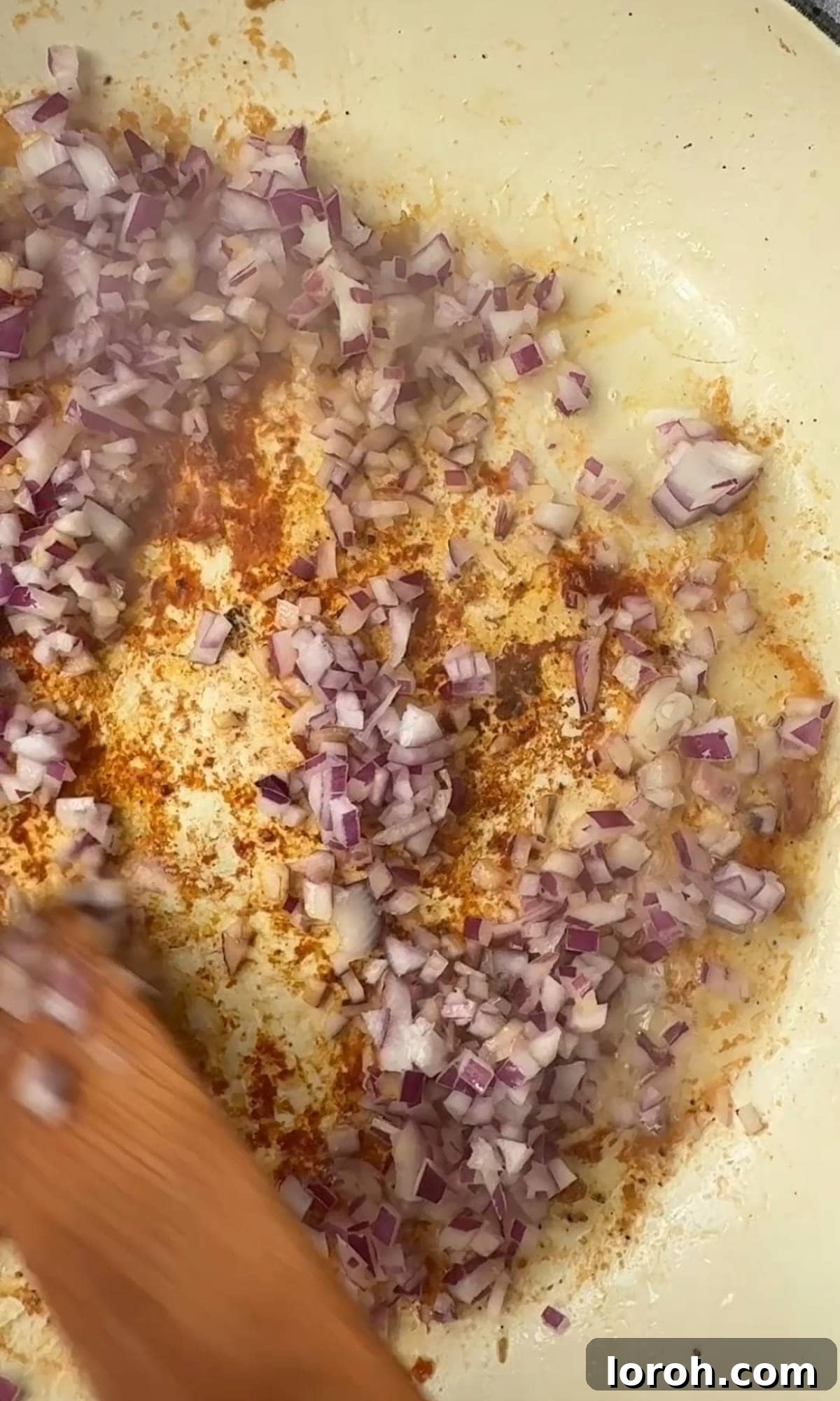 Sautéing red onion in butter and oil in a pan.