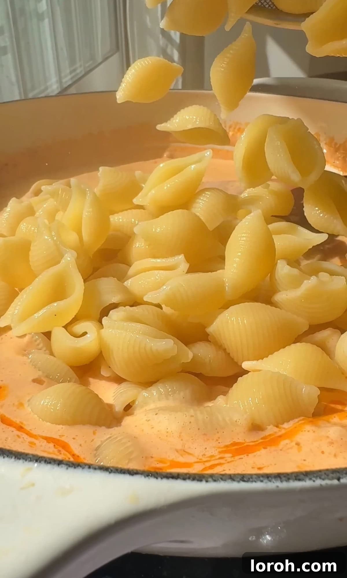 Adding cooked pasta to the parmesan garlic sauce.
