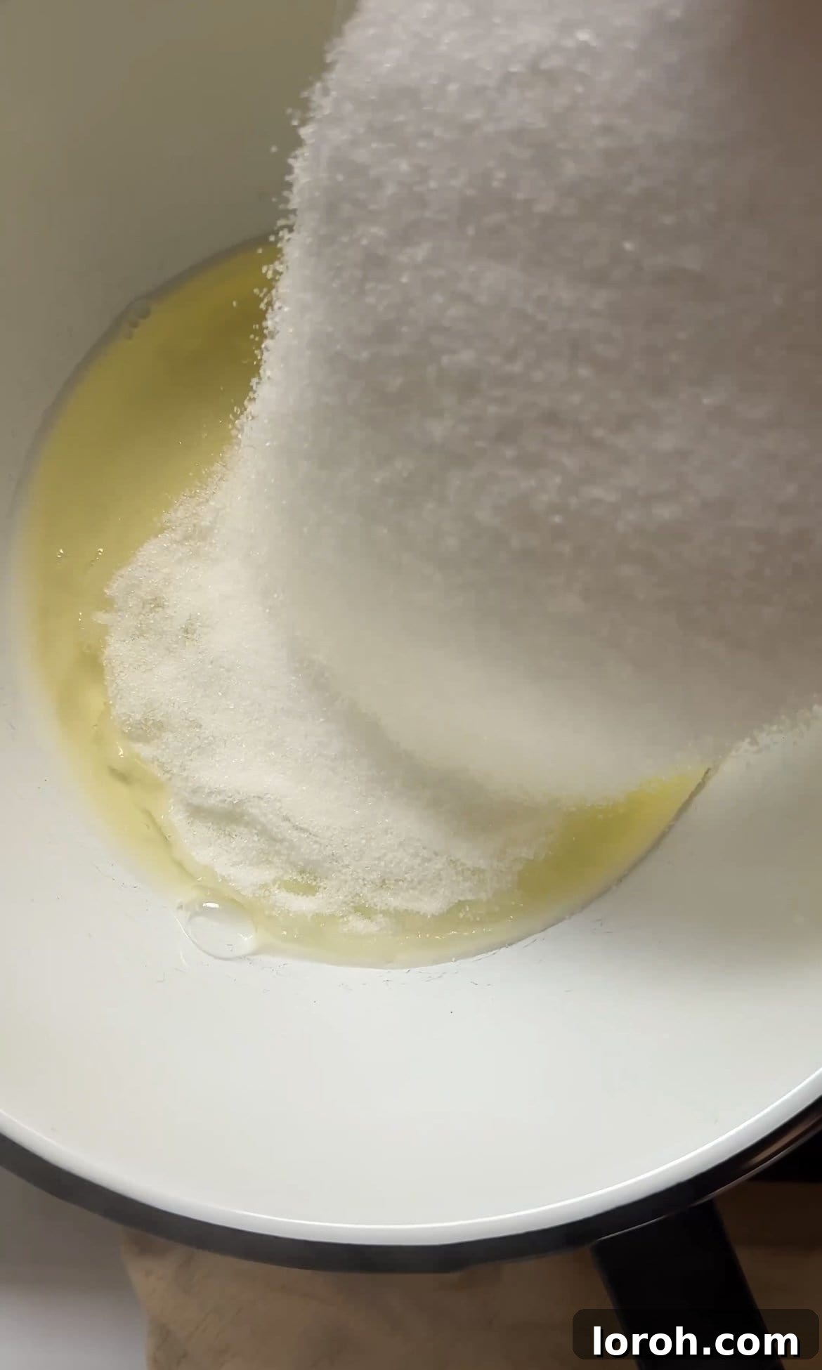 adding sugar to egg whites.