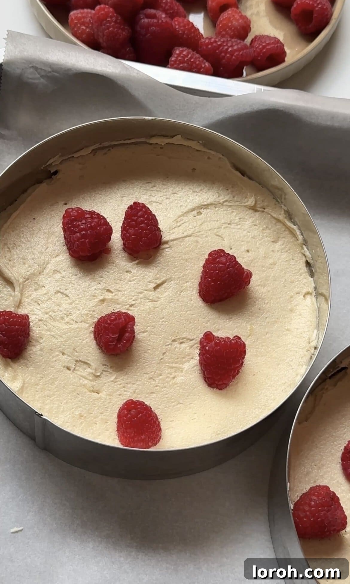adding raspberries into the cake batter.