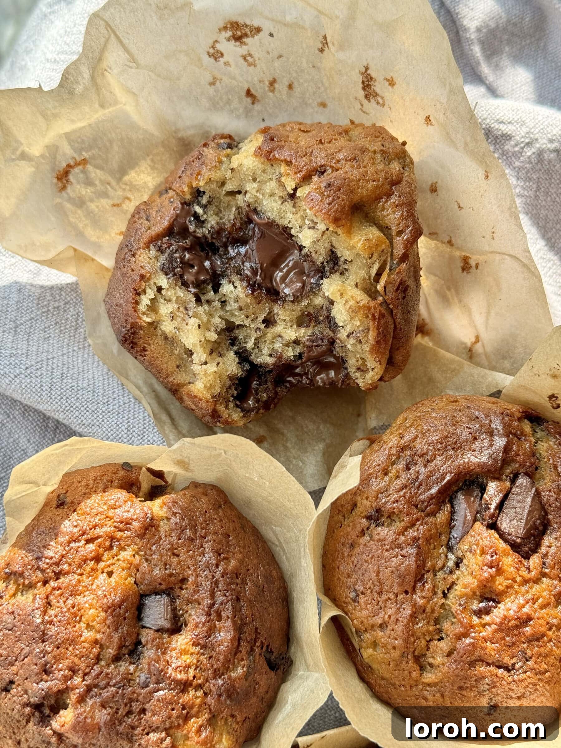 A close-up shot of the raw muffin batter with chocolate chunks folded in, ready for baking.