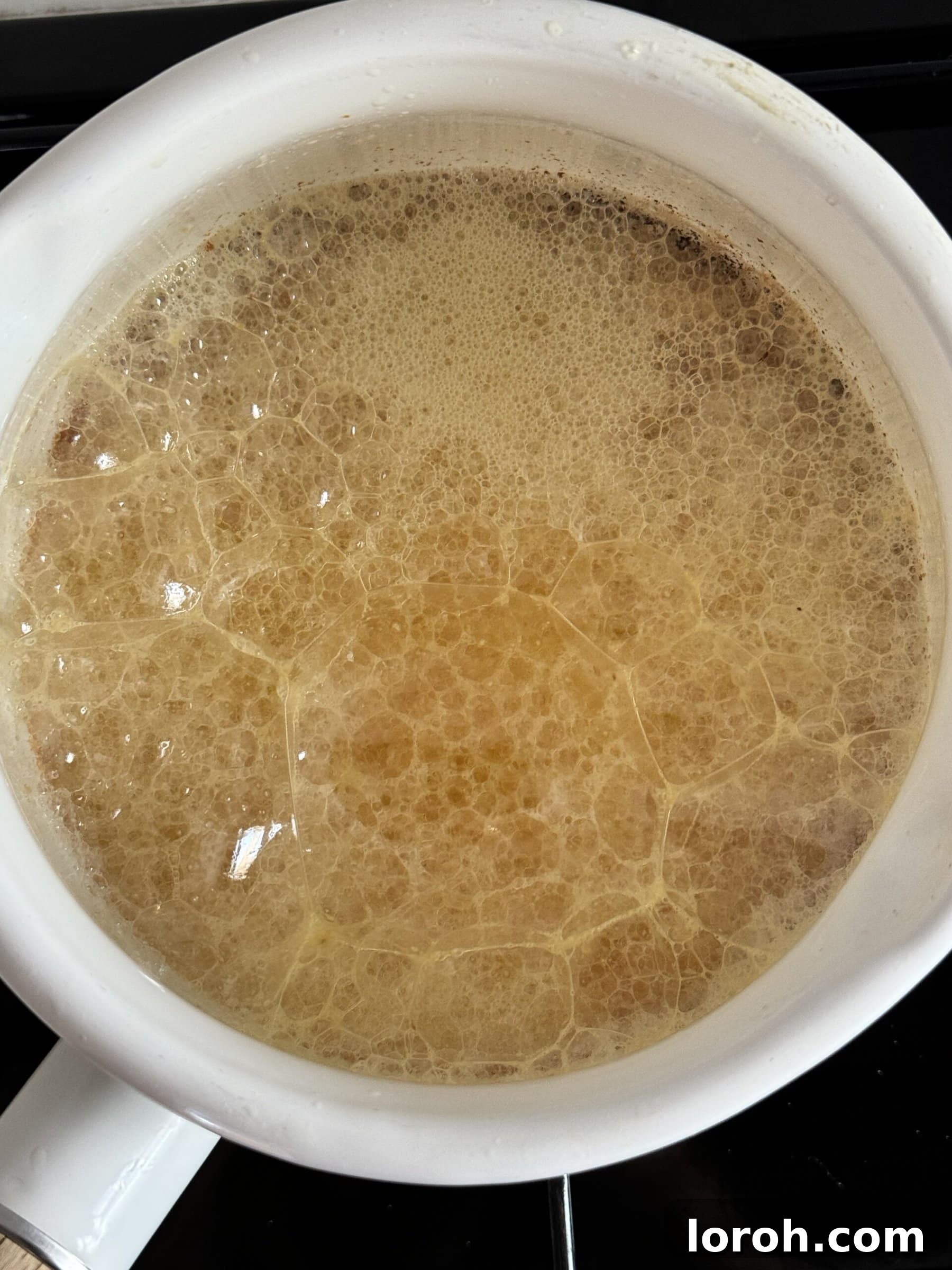 Milk solids beginning to brown at the bottom of the pan.