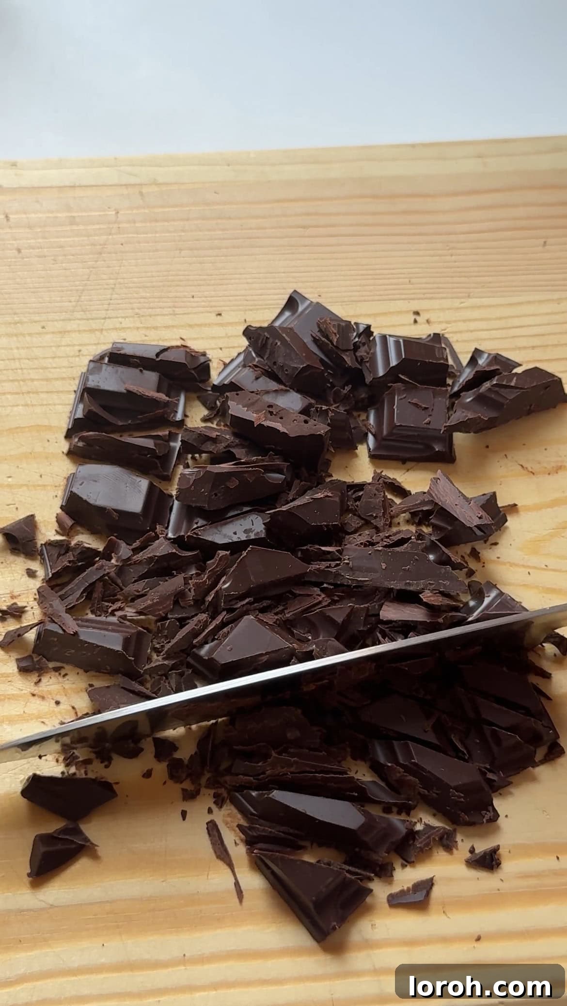 Roughly chopped dark chocolate chunks on a cutting board.