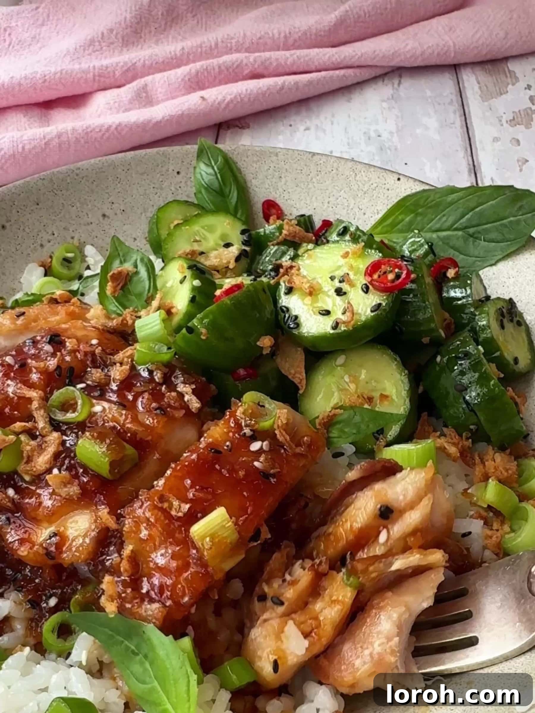 Sticky Soy Garlic Chicken 12 Garlic and Soy chicken in a bowl with rice and cucumber salad, overhead shot