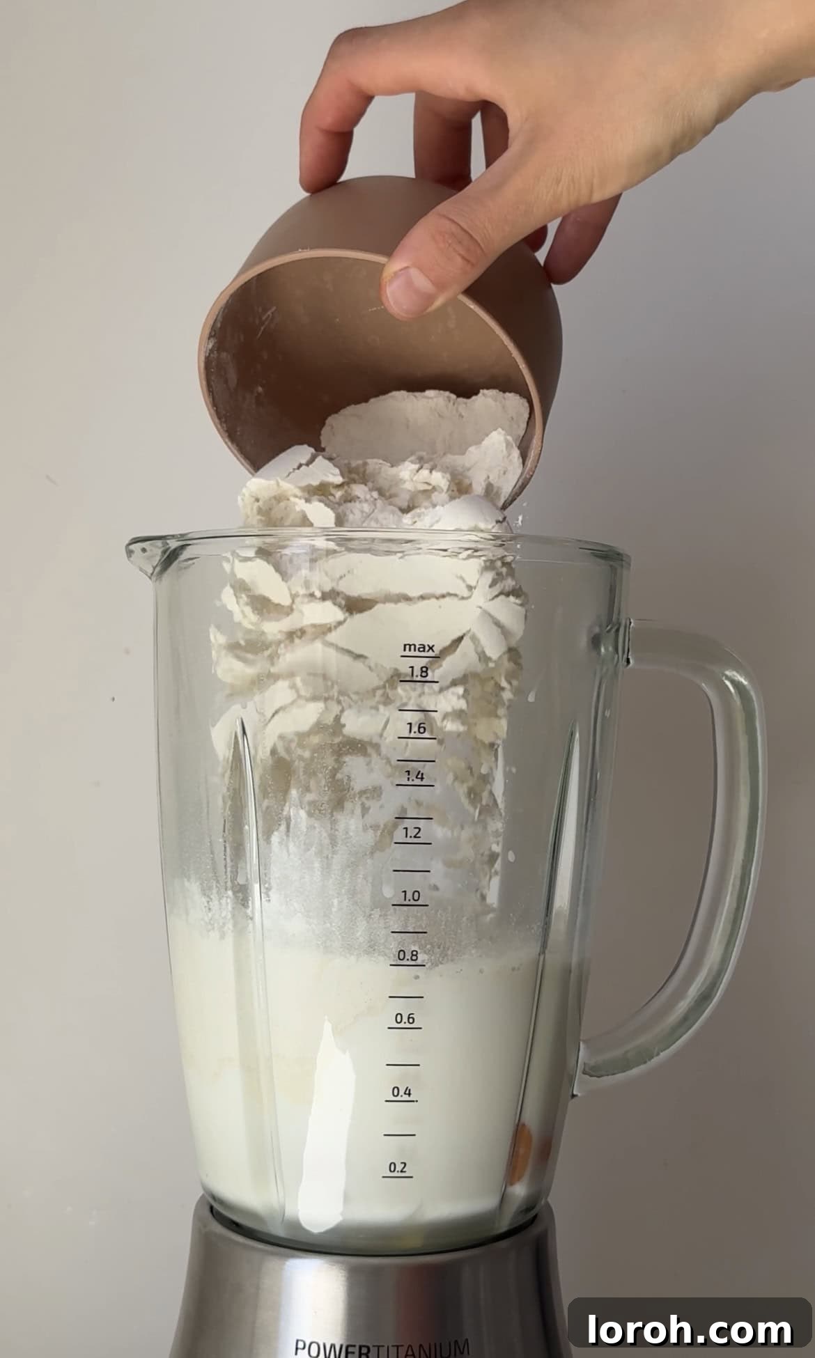 Mixing crepe batter in a blender for a smooth consistency.