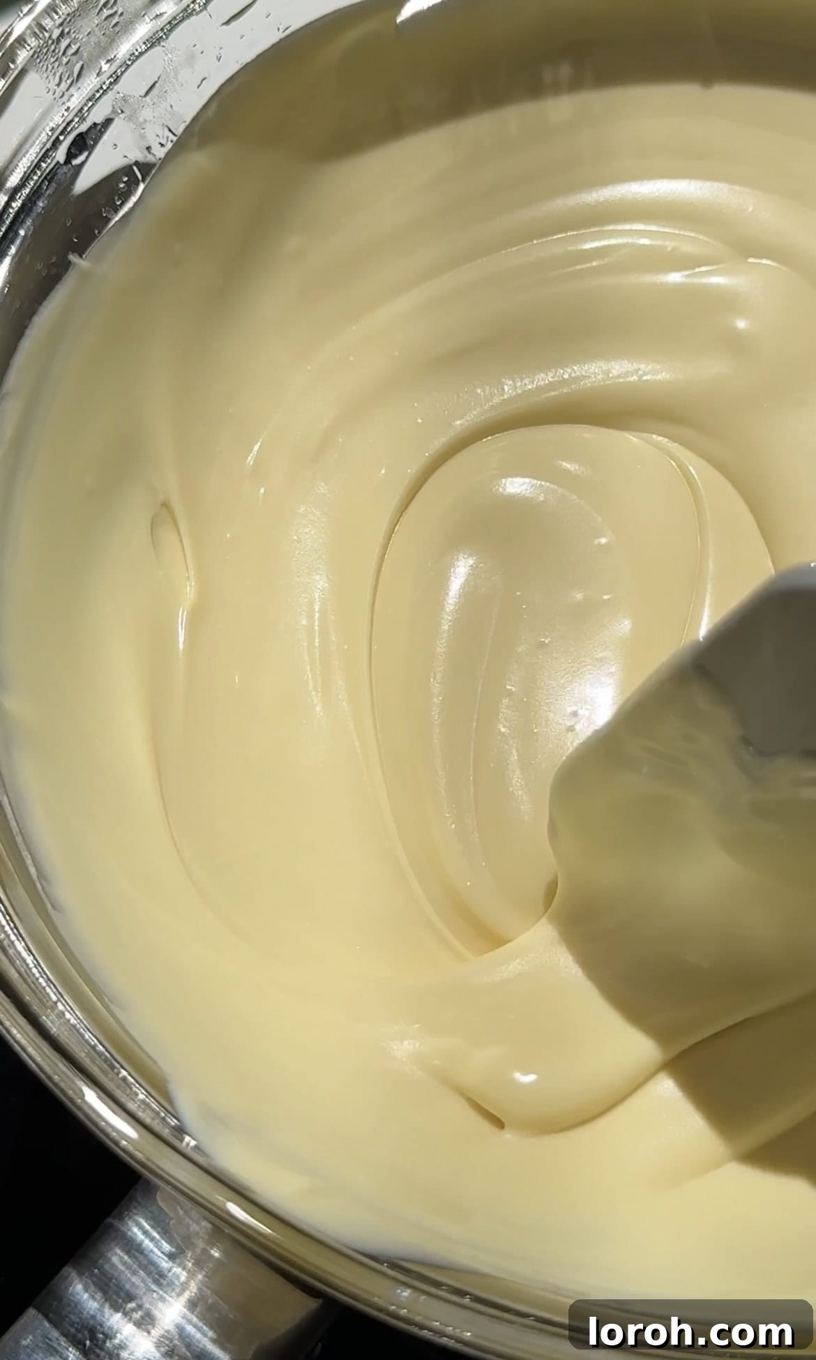 Melting chopped white chocolate in a heat-proof bowl over simmering water.
