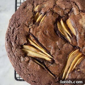 Close-up of a perfectly baked chocolate and pear cake on a wire rack.