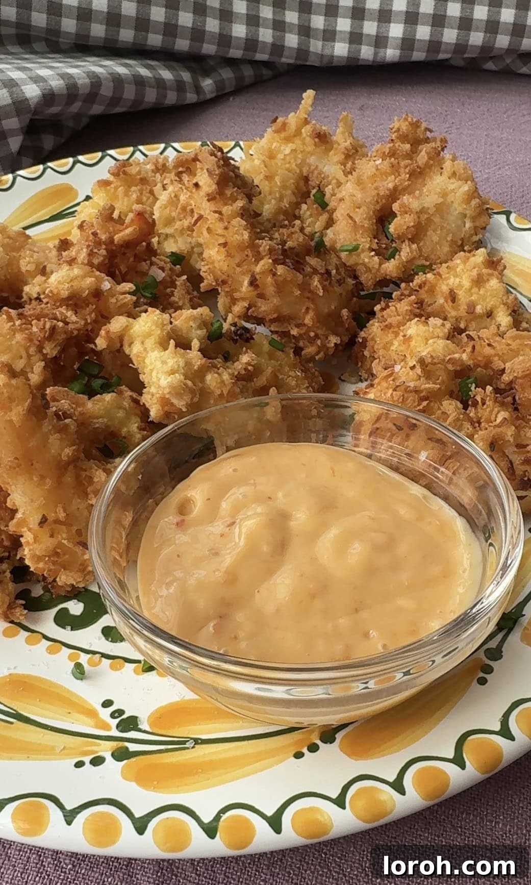 Golden Crispy Panko Shrimp 11 Serving fried panko shrimp with a side of dipping sauce and a sprinkle of fresh chives.