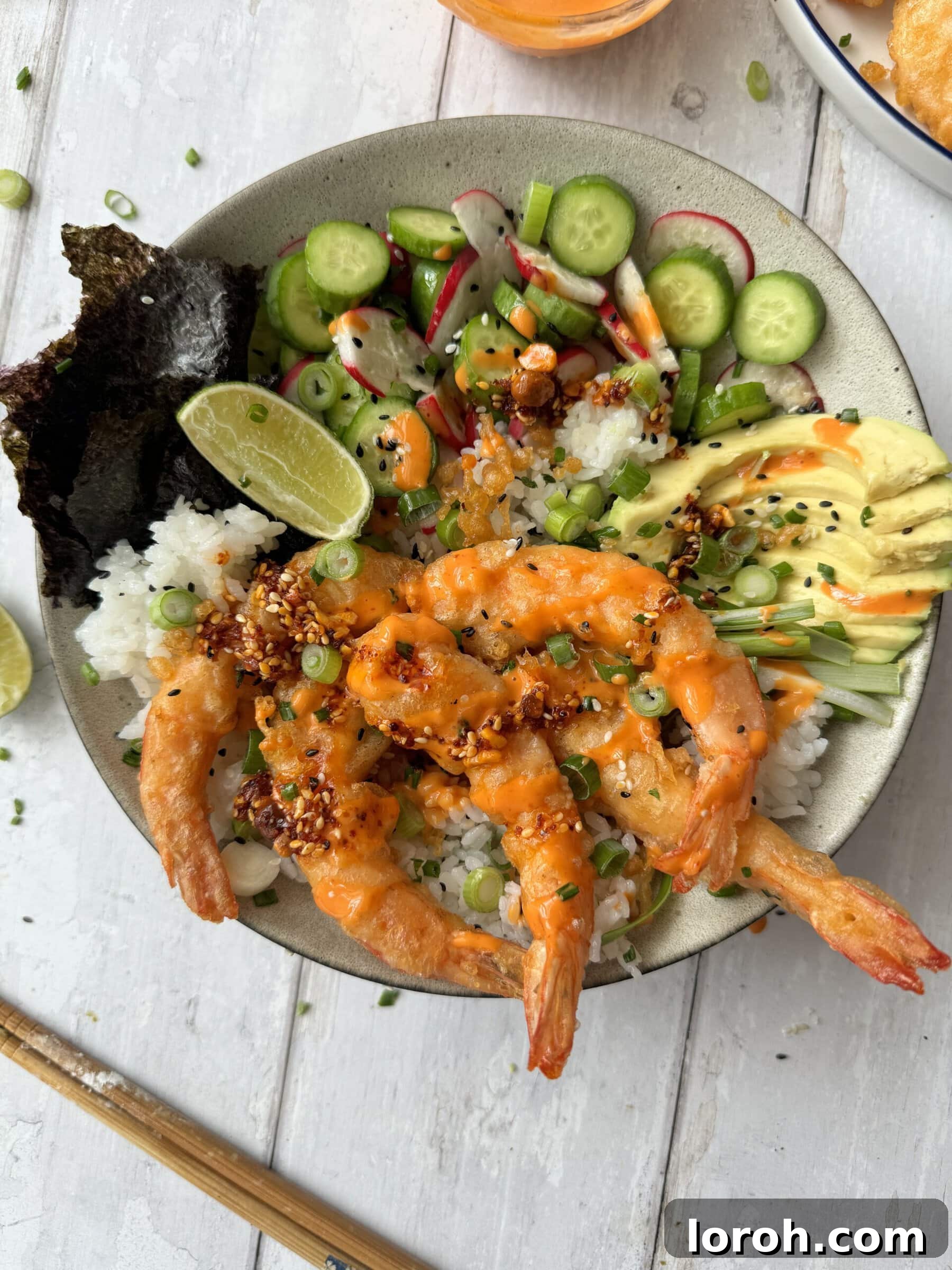 Golden Crispy Ebi Tempura 4 A vibrant Ebi Tempura rice bowl featuring avocado, cucumber, and crispy tempura prawns.