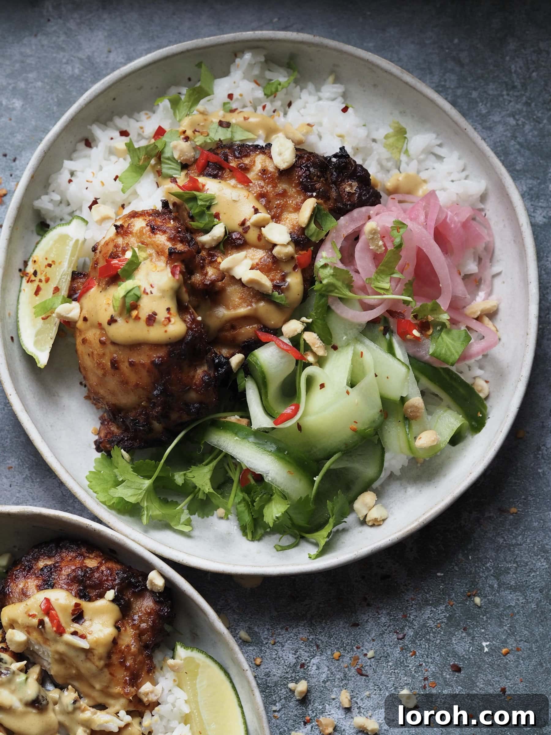 Overhead shot of two Chicken Satay Rice Bowls, ready to eat