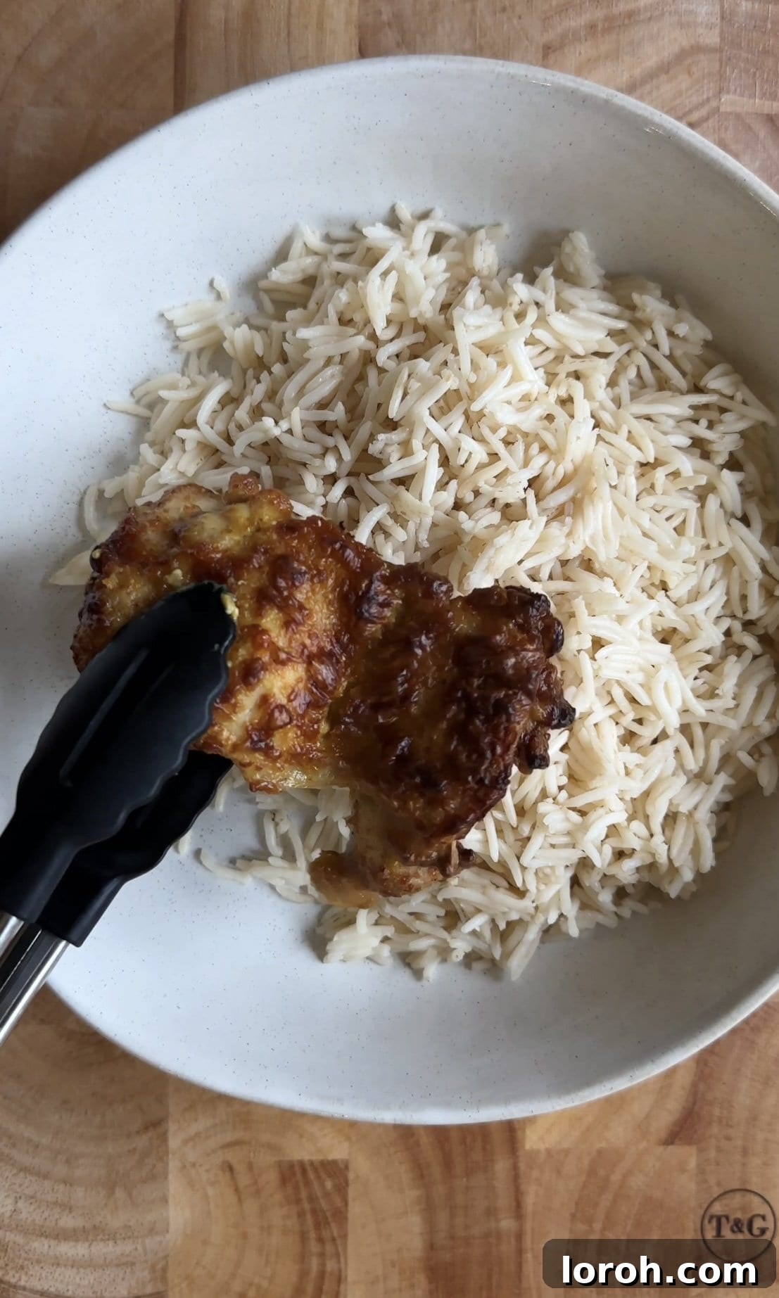 Assembling a chicken satay rice bowl with chicken and sauce