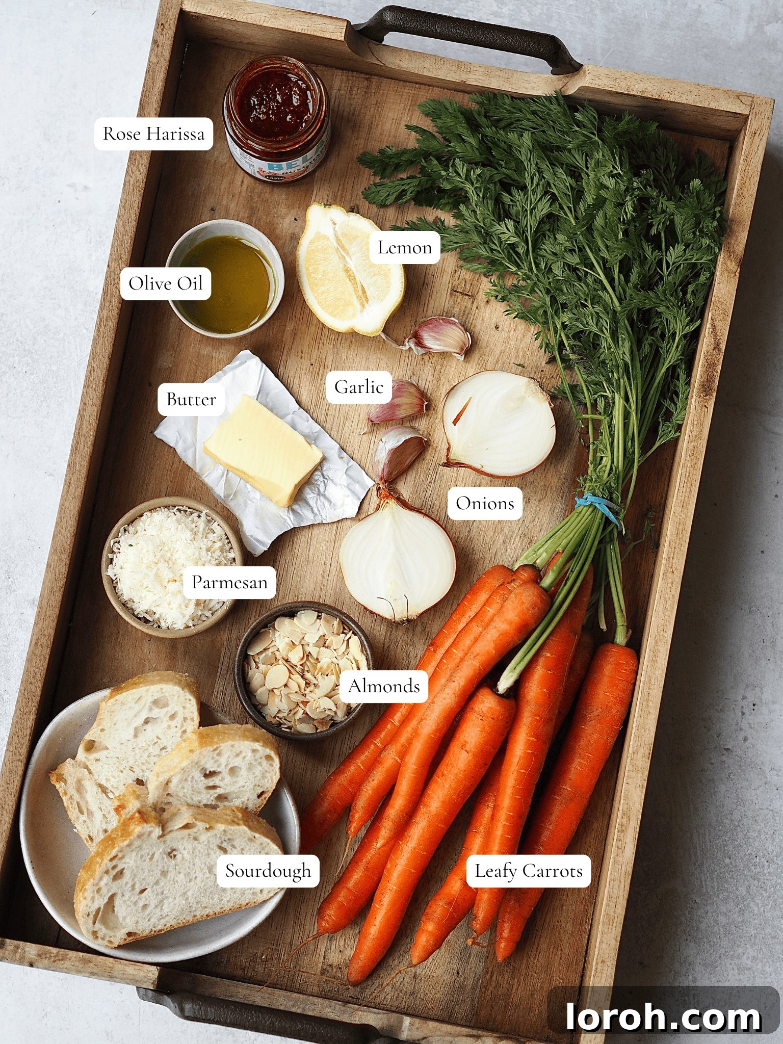 Smoky Harissa Carrot Velouté 3 Labelled ingredients to make carrot and harissa soup on a wooden tray.