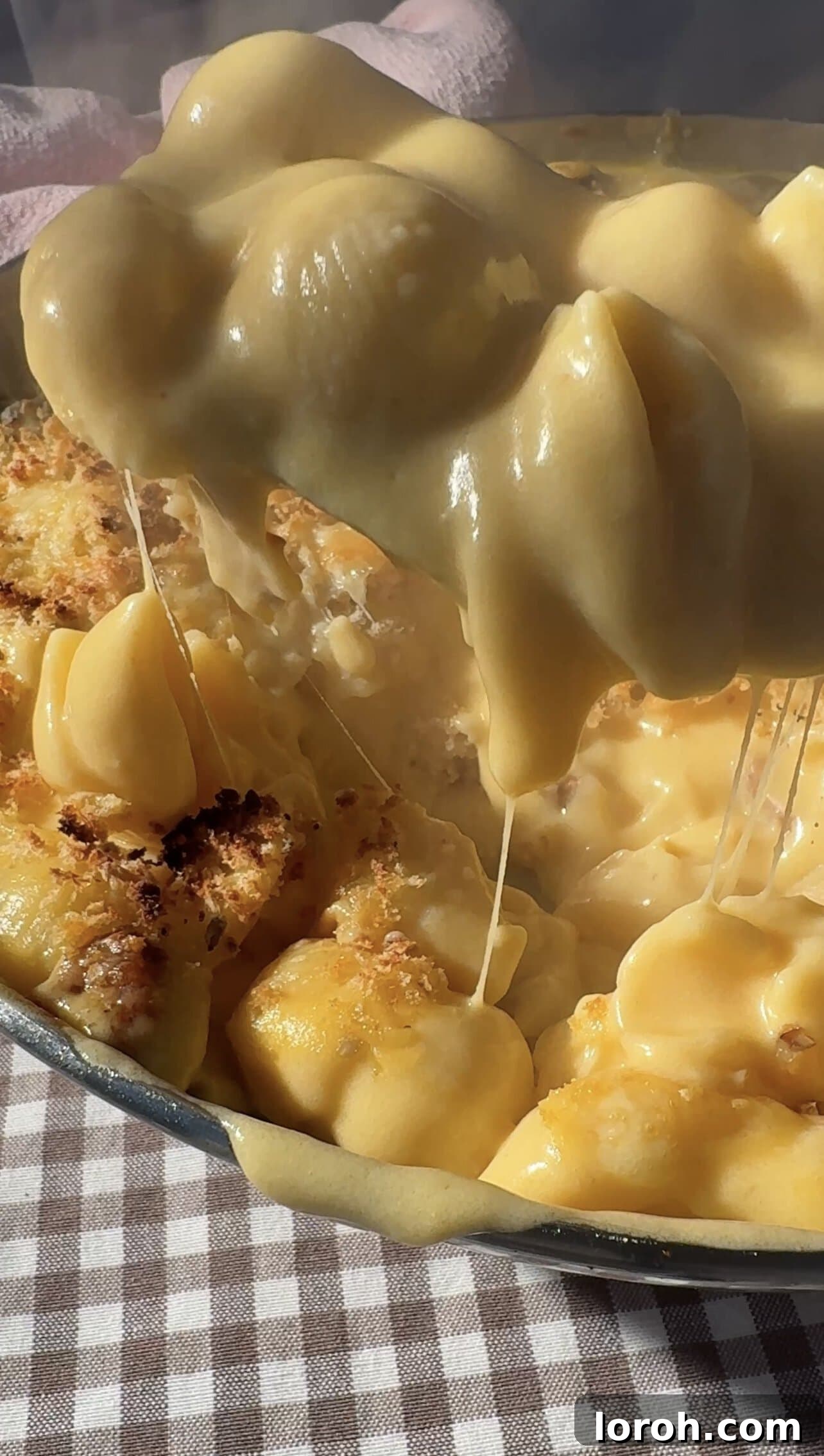 Decadent Gouda Mac and Cheese 2 Scooping rich, creamy Gouda Mac and Cheese from a baking dish, showcasing melted cheese and crispy topping.
