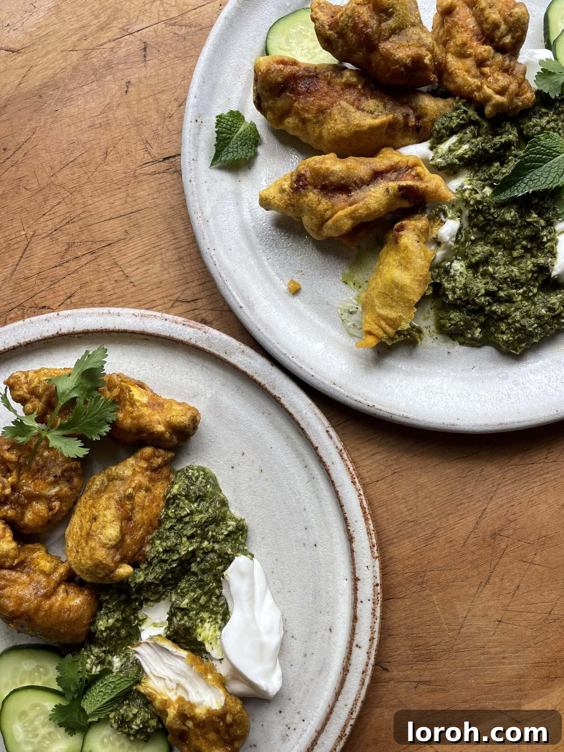 Serving platter of hot Chicken Pakora garnished with fresh mint and lime.