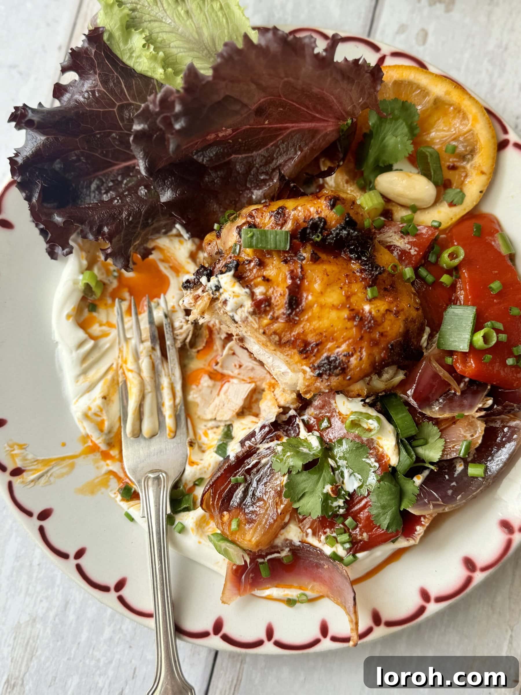 harissa chicken on platter with labneh, close up of crispy skin