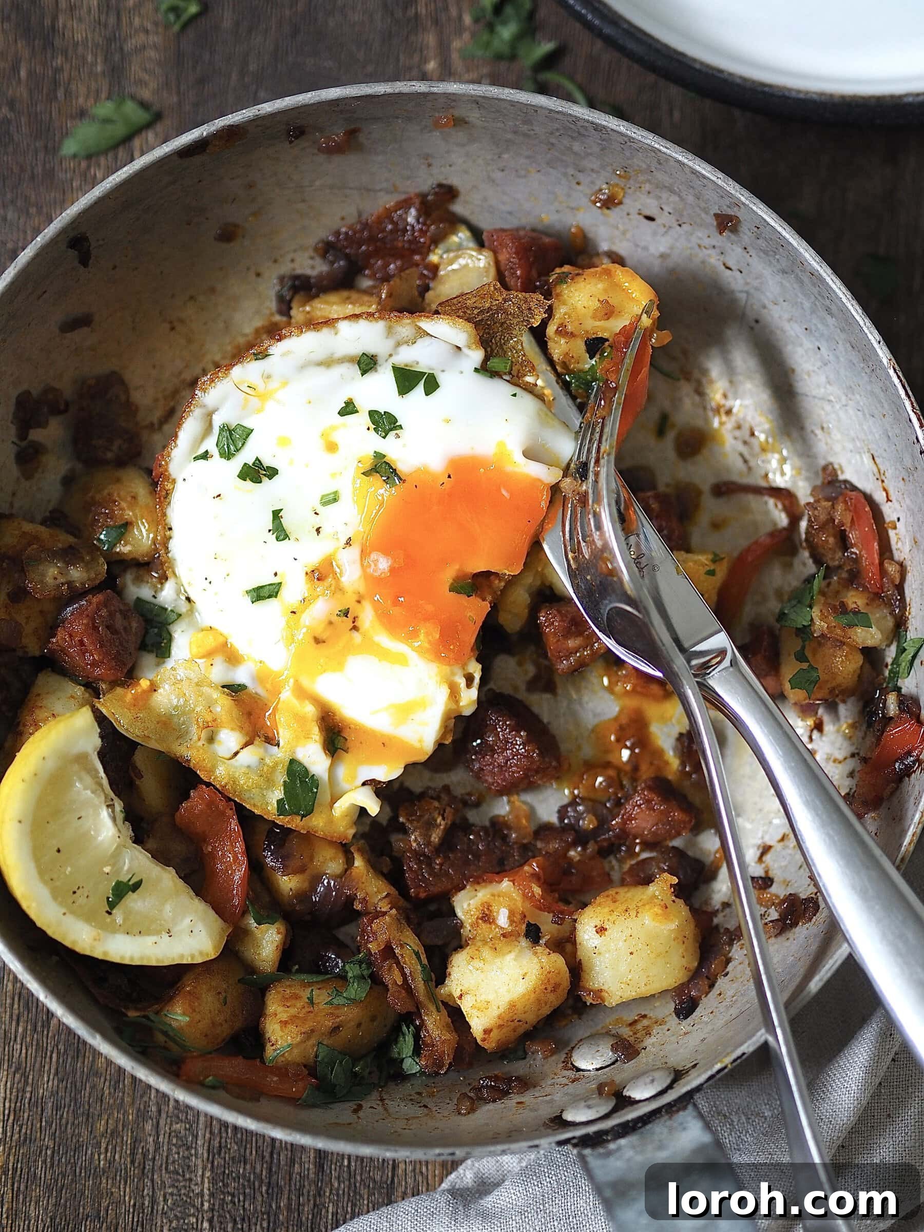 Smoky Chorizo and Potato Morning Skillet 11 A vibrant plate of Chorizo and Potato Breakfast Hash, garnished with fresh herbs and a lemon wedge.