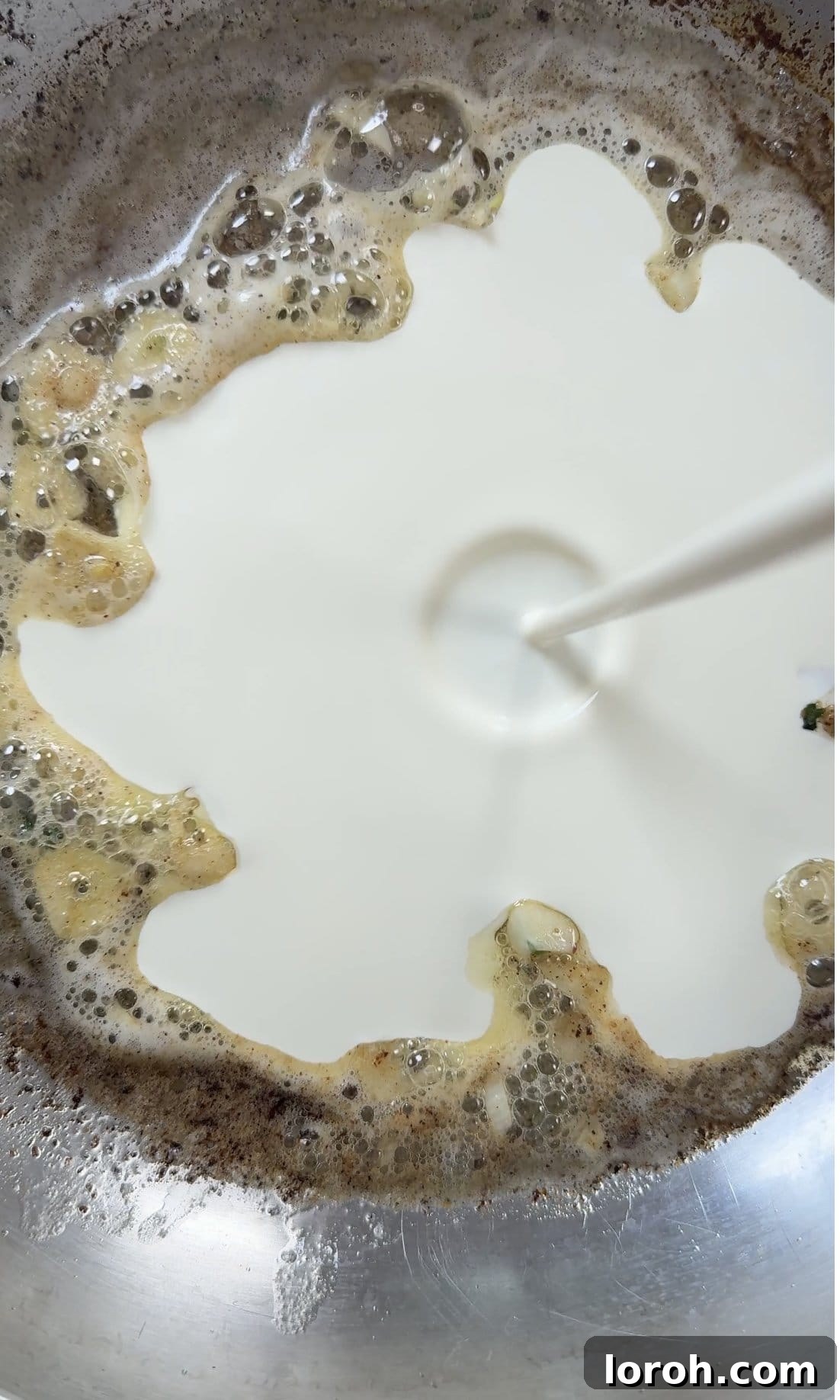 Velvety Chicken Pasta 7 Pouring rich double cream into the pan with sautéed garlic and butter to create the creamy base for the pasta sauce.