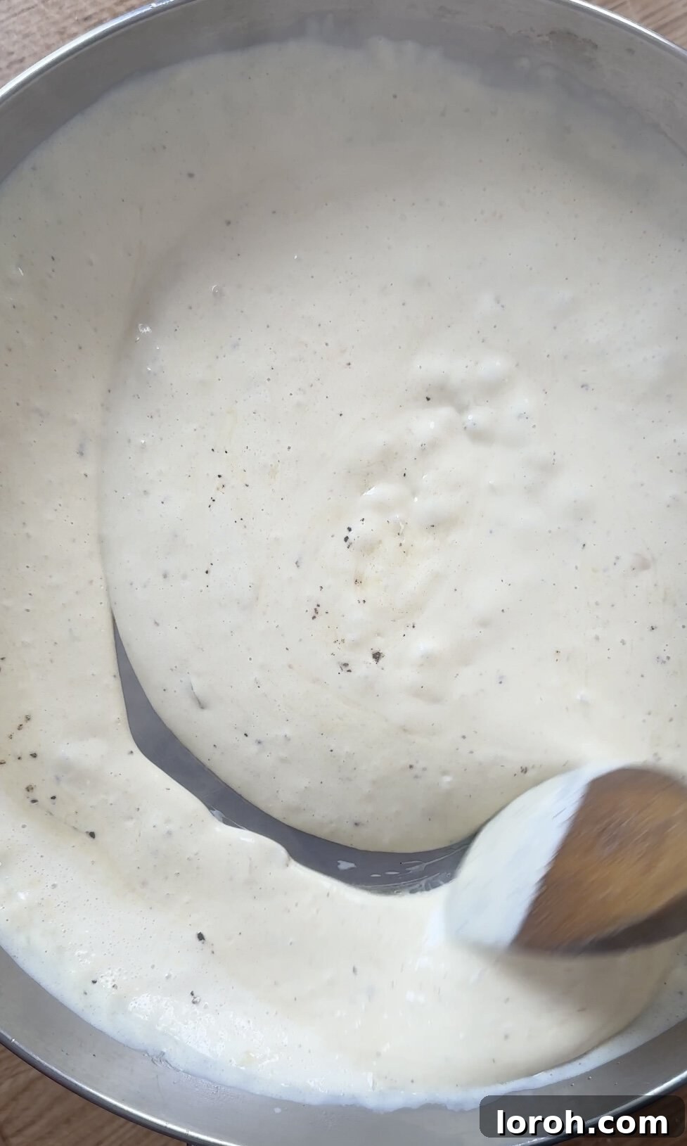 Velvety Chicken Pasta 9 Stirring the creamy chicken sauce in the pan, showing its smooth texture.