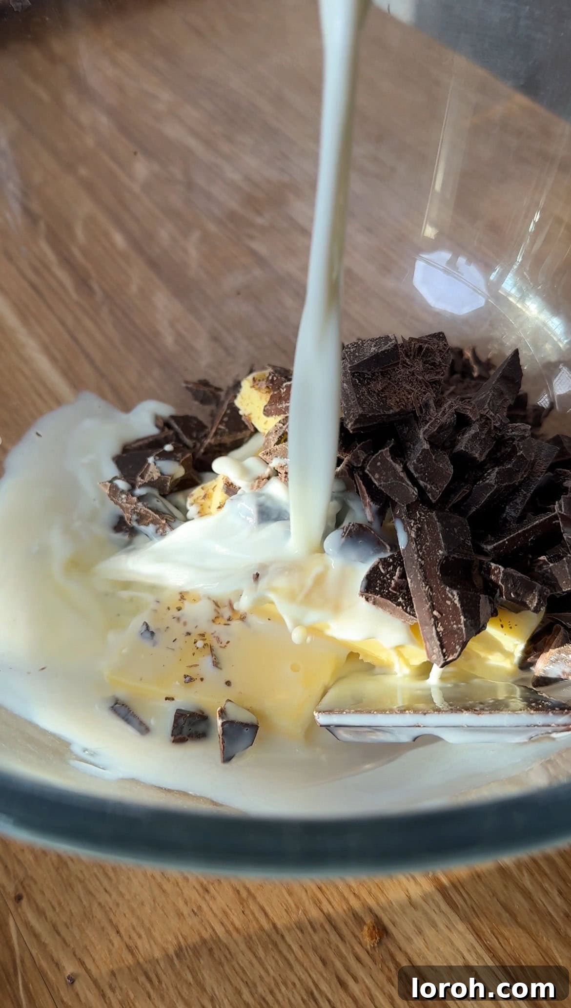 Melting dark chocolate, cubed butter, and milk in a heatproof bowl, stirred to combine into a smooth mixture.