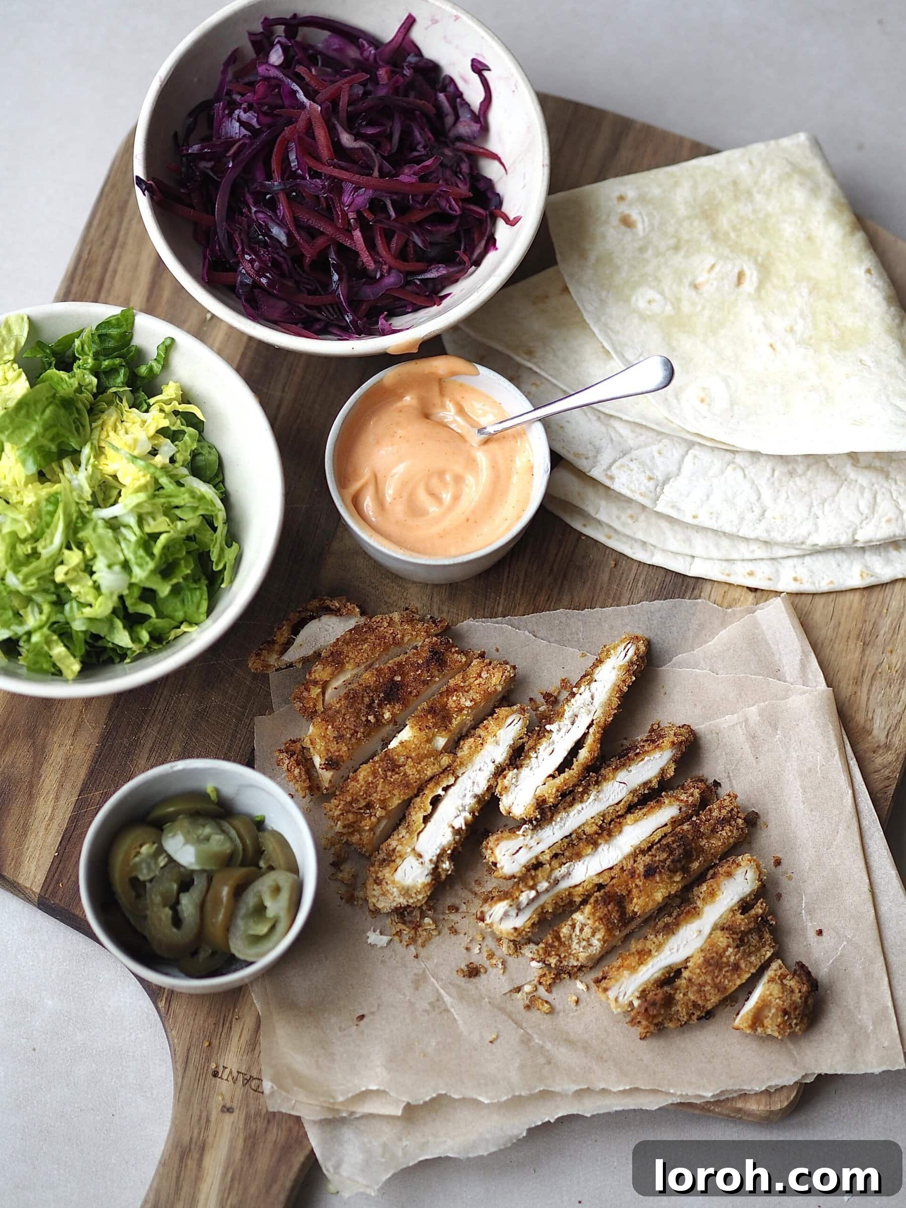 Katsu Crunch Wrap 4 Two freshly prepared Chicken Katsu Wraps on a wooden board, ready to be served.