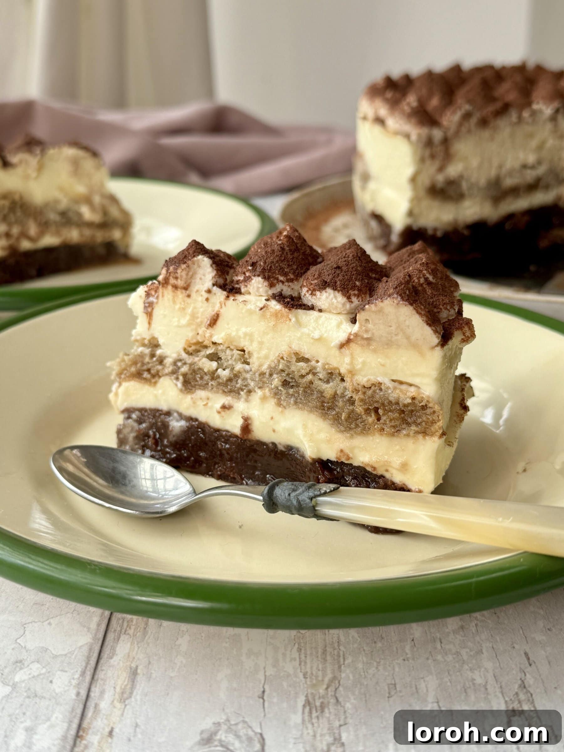 Decadent Brownie Tiramisu Cheesecake with Malted Whipped Bliss 3 A perfectly sliced piece of Tiramisu Cheesecake on a white plate, showcasing its distinct layers.