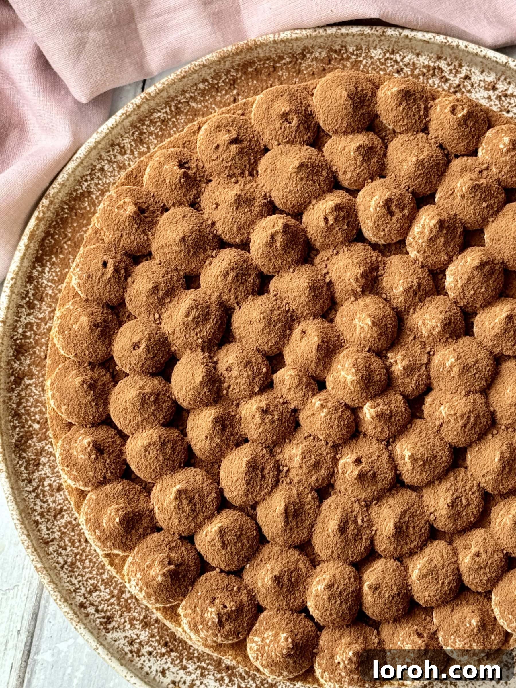 Decadent Brownie Tiramisu Cheesecake with Malted Whipped Bliss 4 A full Tiramisu Cheesecake with whipped cream peaks and cocoa powder dusting, ready to be served.