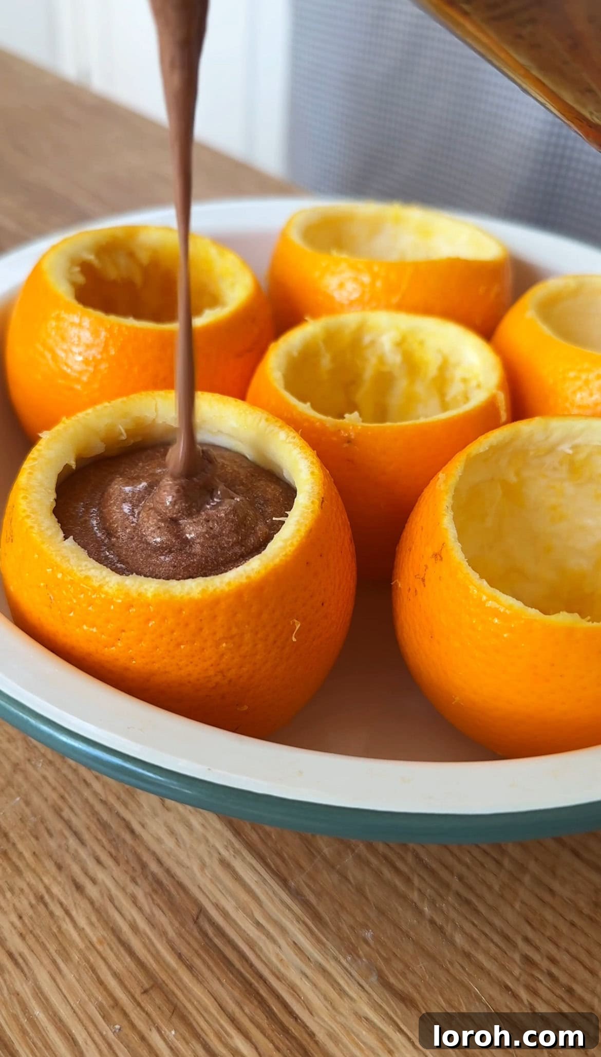 Citrus Cocoa Cloud 11 Finished chocolate orange mousse being spooned into hollowed-out orange halves, ready for chilling and serving.