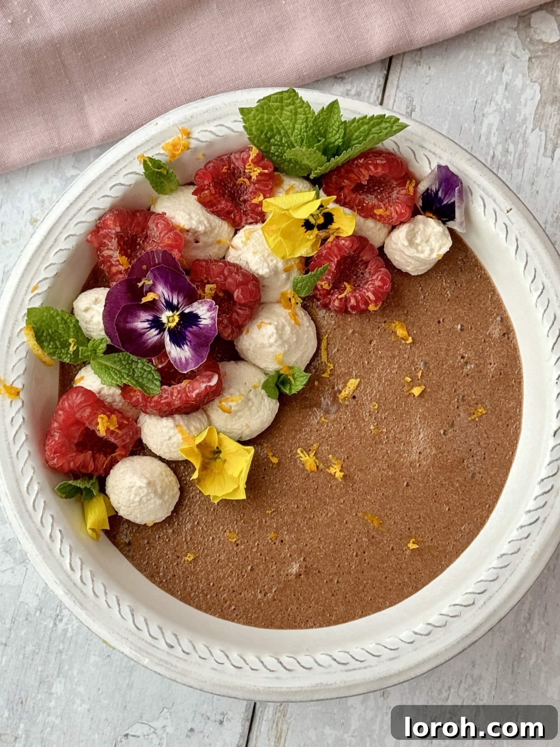 Citrus Cocoa Cloud 13 A large bowl of smooth chocolate orange mousse, garnished with fresh berries, orange zest, and mint, showcasing an alternative elegant serving.