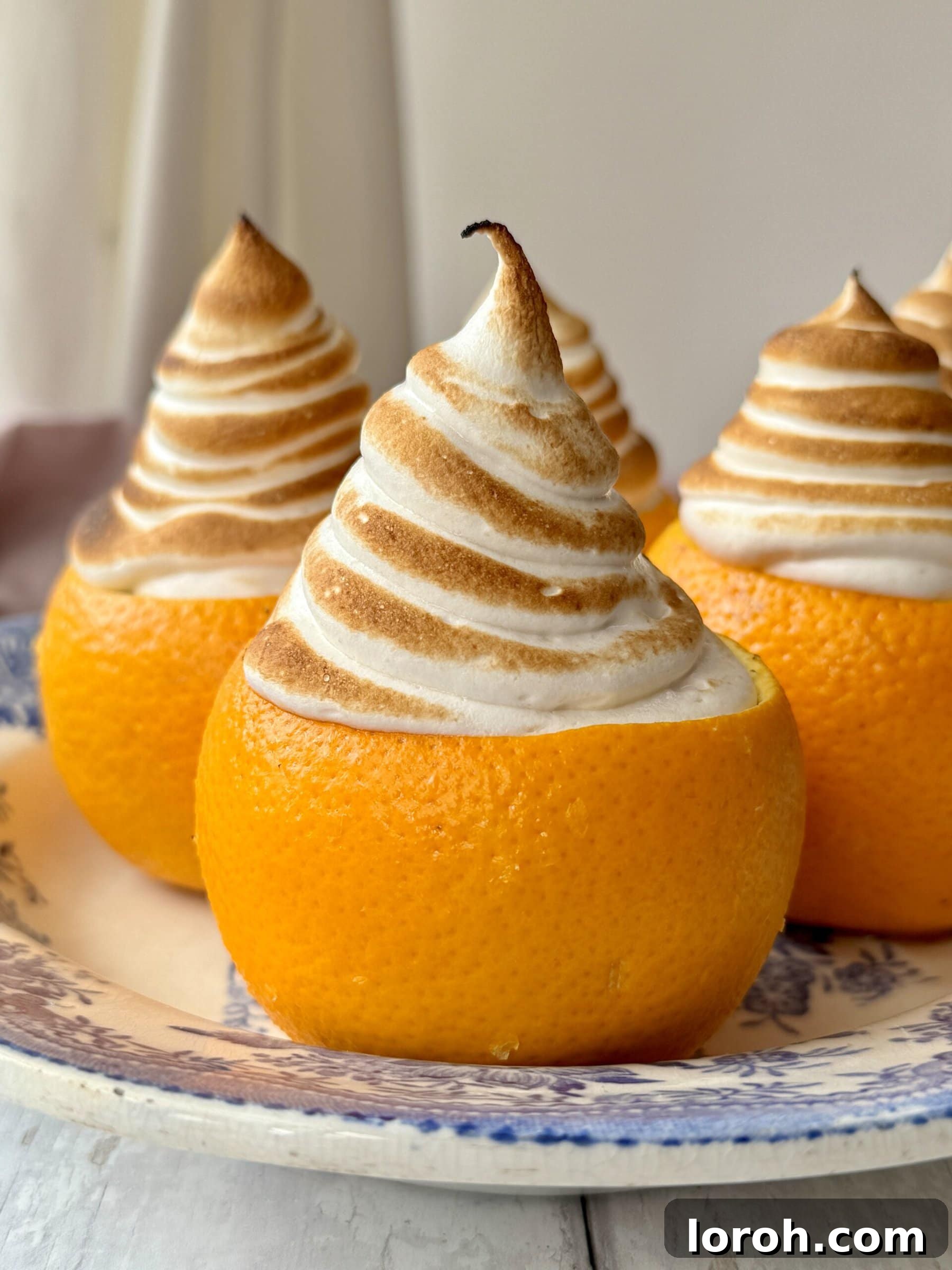 Citrus Cocoa Cloud 5 A stunning close-up of a chocolate orange mousse in an orange cup, topped with perfectly torched brown sugar meringue, ready to be served.
