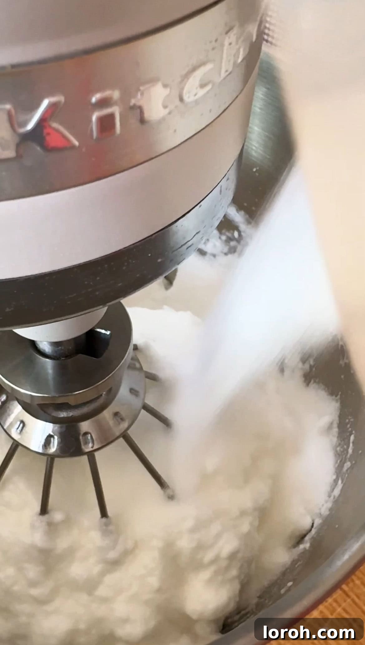 Citrus Cocoa Cloud 8 Egg whites being whipped with caster sugar in a large bowl using an electric whisk until they form glossy, stiff peaks.