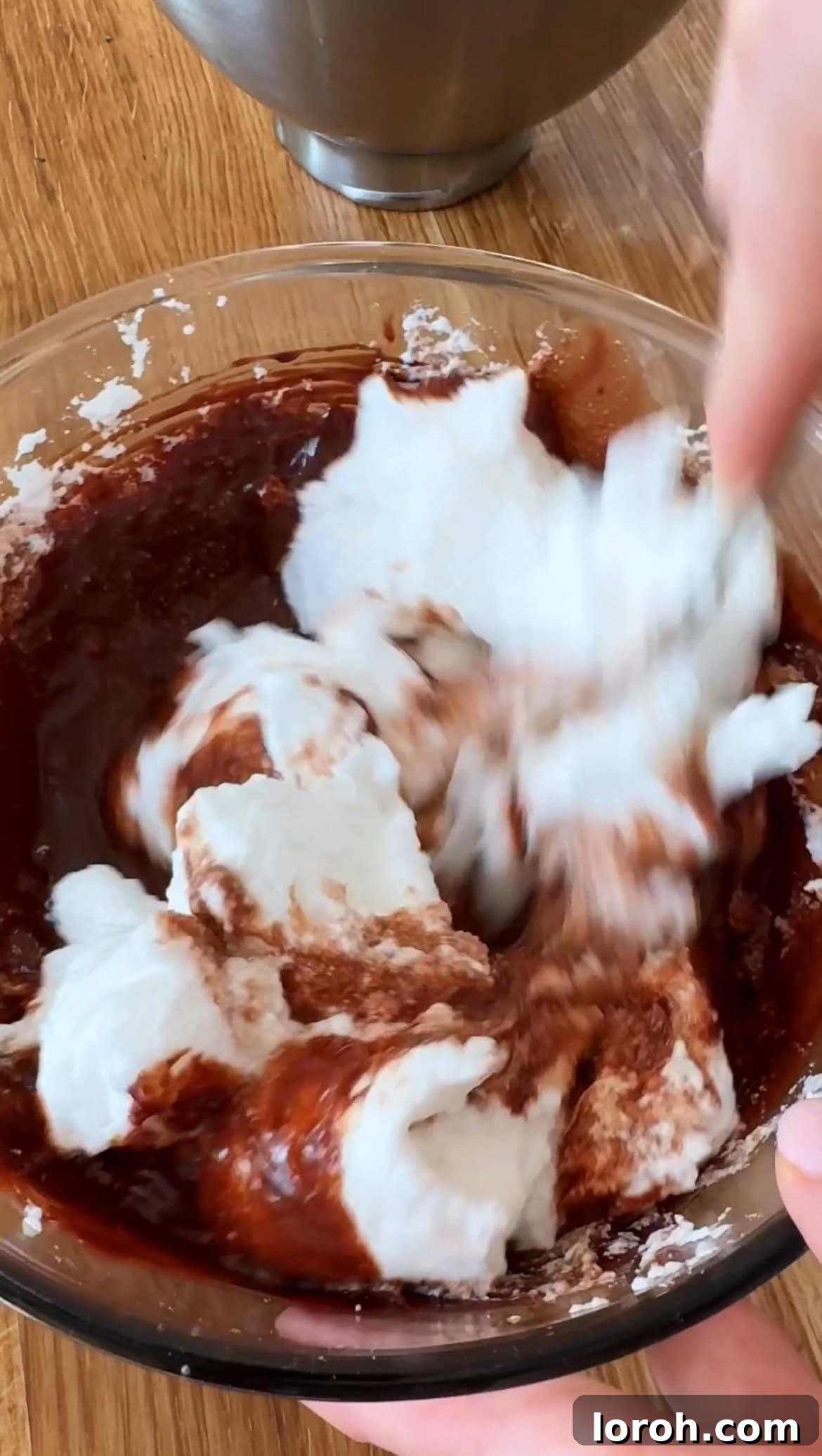 Citrus Cocoa Cloud 9 The first third of whipped egg whites being gently incorporated into the rich chocolate mixture to lighten its texture.
