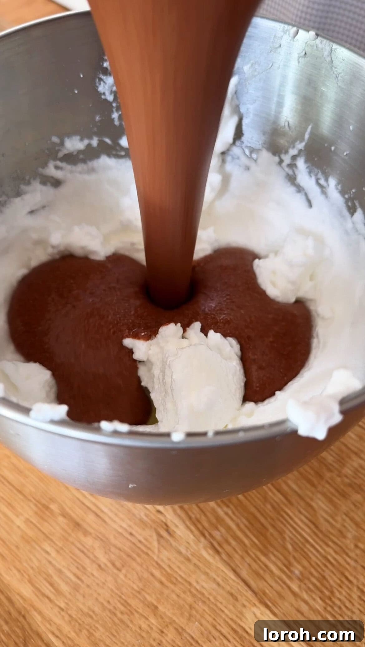 Citrus Cocoa Cloud 10 The loosened chocolate mixture being carefully transferred and folded into the remaining whipped egg whites to maintain airiness.