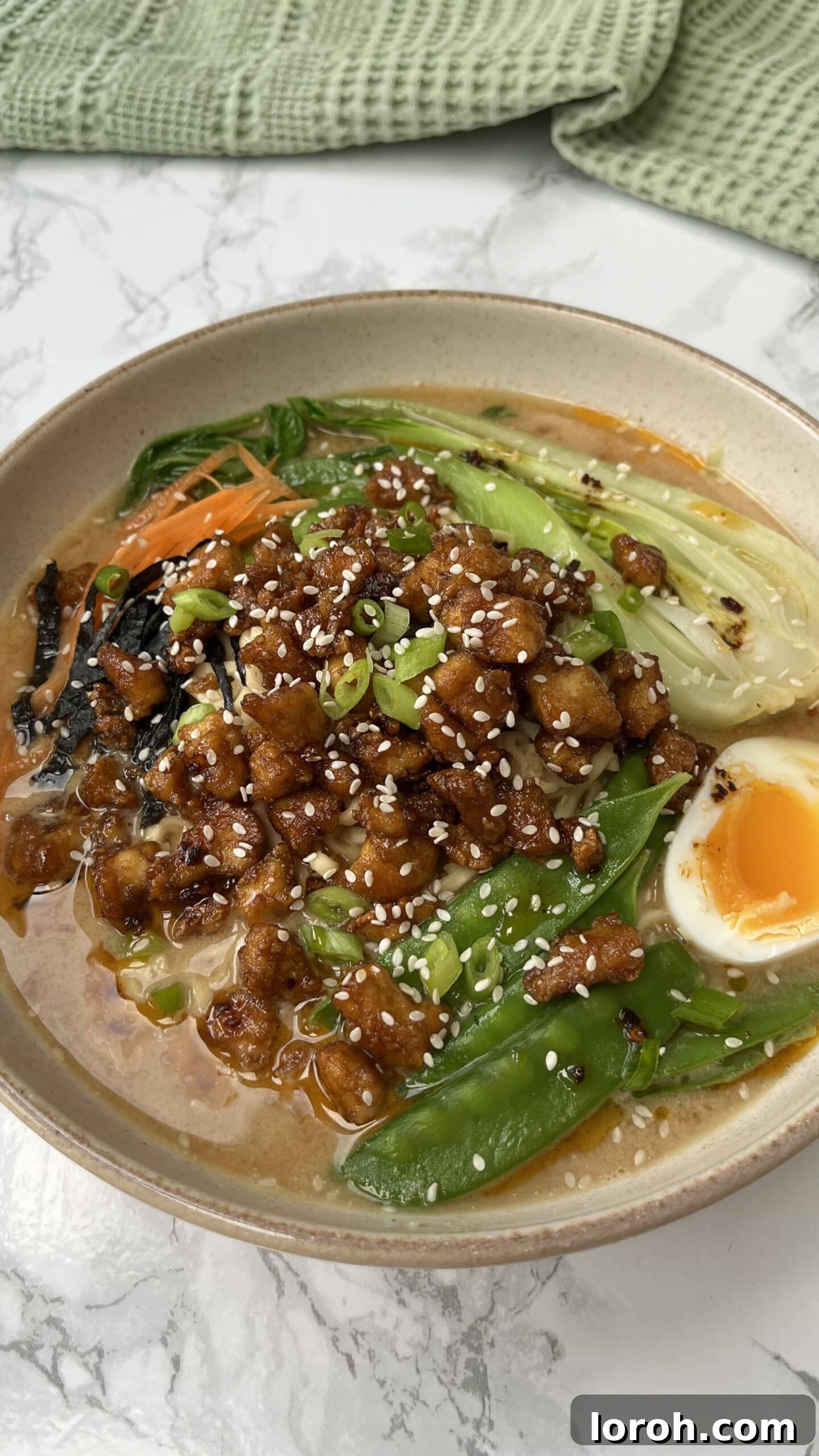 A delectable Tofu Noodle Soup in a bowl, garnished with green onions and a perfectly boiled egg.