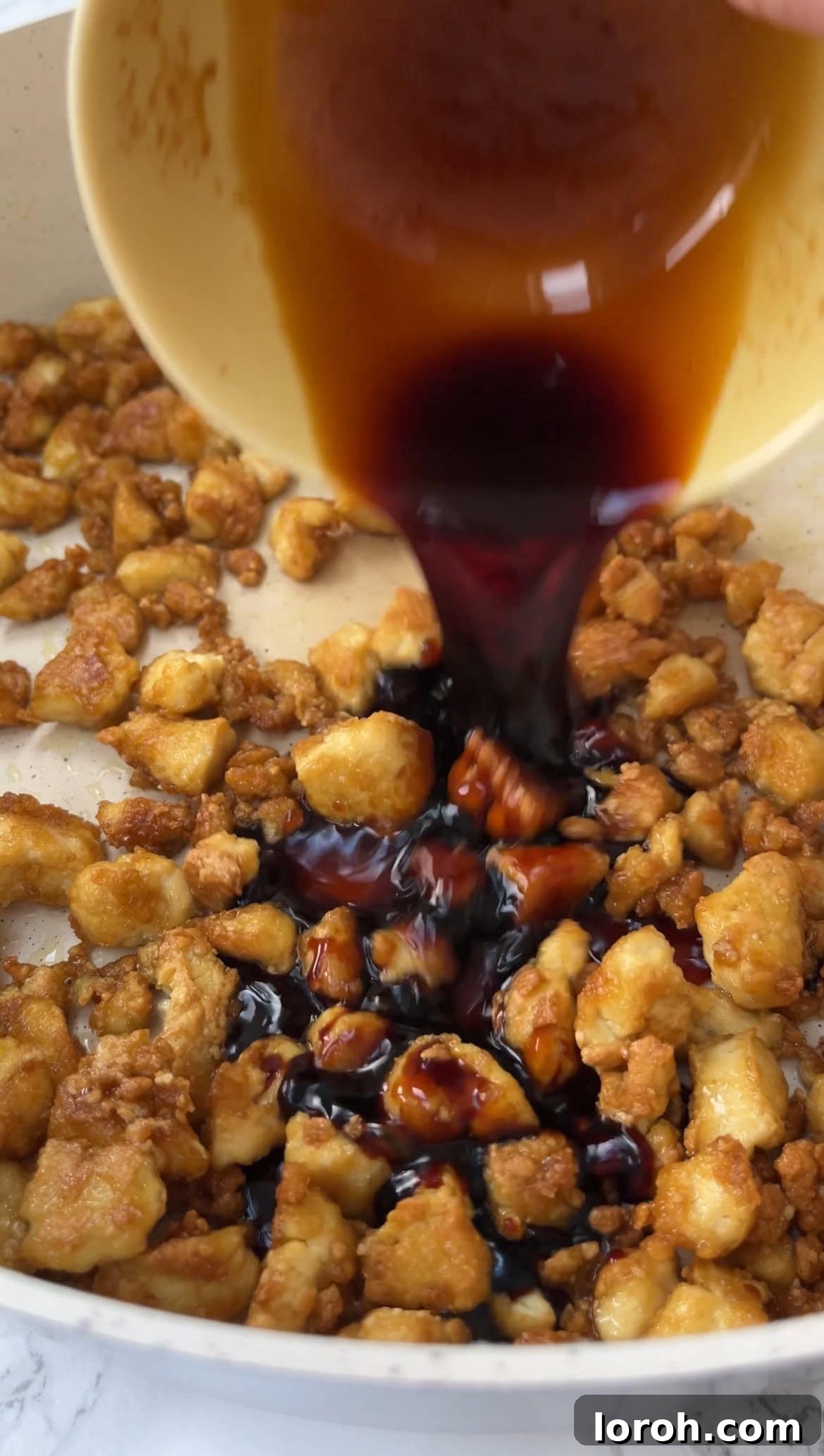 Tossing crispy tofu in a rich, sticky glaze made from soy sauce, garlic, sugar, and mirin.