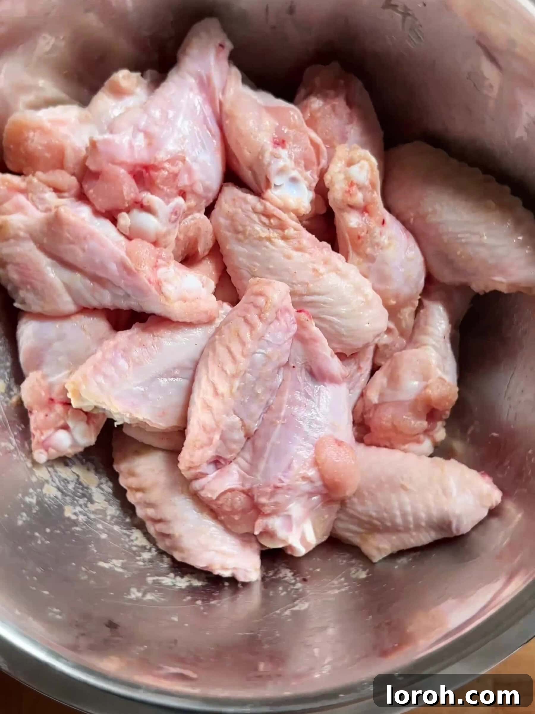 Patting the chicken wings dry with paper towel for ultimate crispiness.