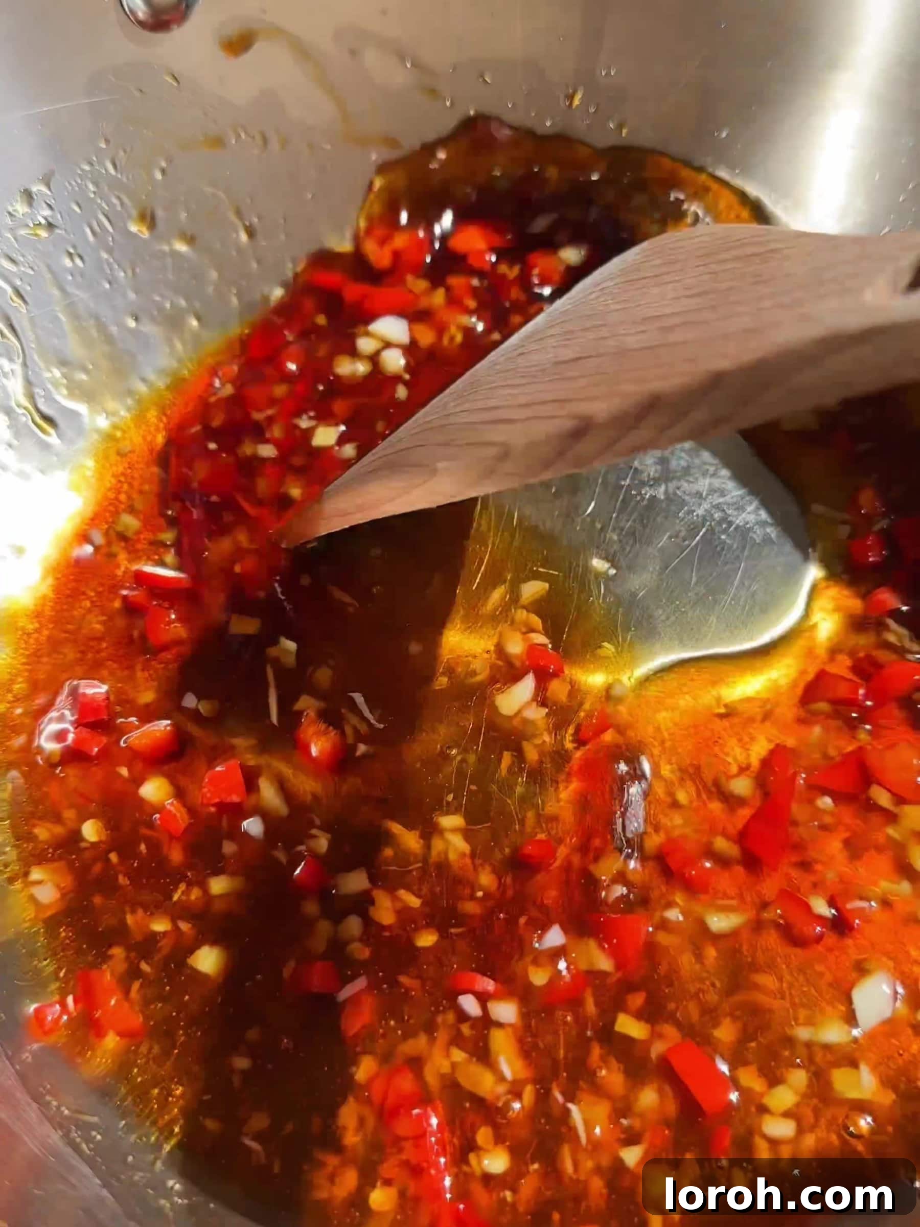Sautéing aromatics for the hot honey sauce in a pan.