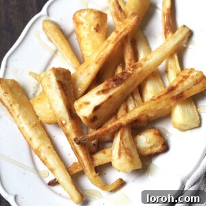White platter of roasted parsnips drizzled with honey.