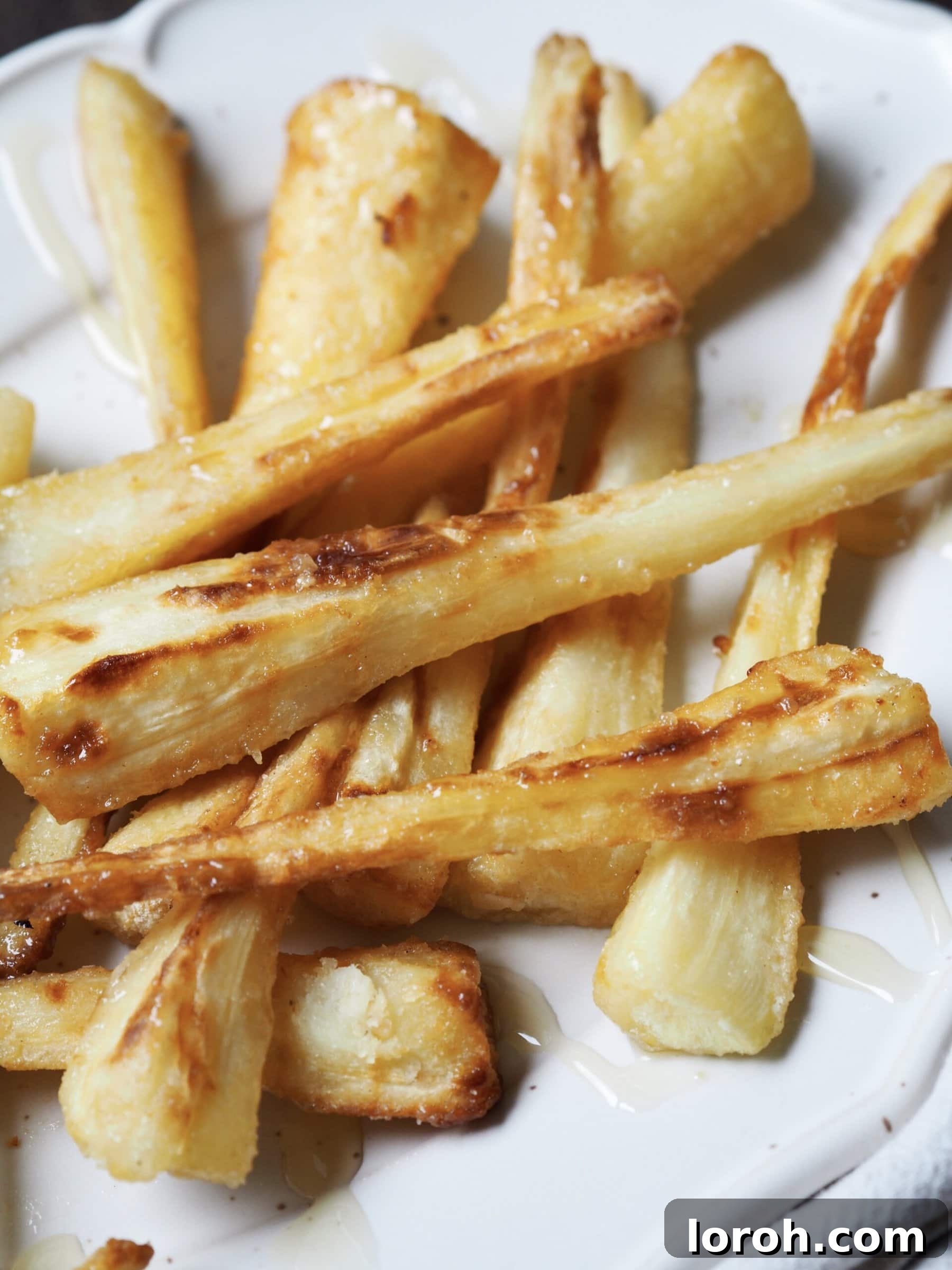 Coated parsnips carefully arranged in the air fryer basket.
