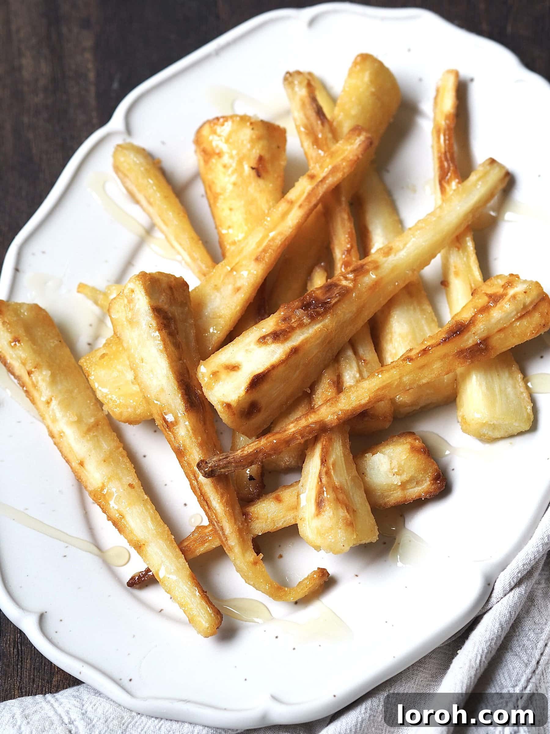 Finishing touch: honey being drizzled over roasted parsnips in the air fryer basket.