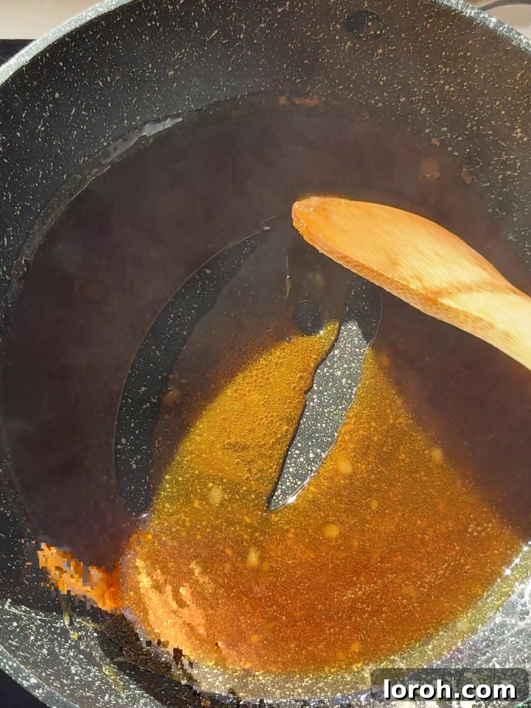 Caster sugar melting in a heavy-based saucepan over medium heat, beginning to turn into liquid caramel.