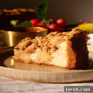 A perfect slice of Apple Crumble Cheesecake on a beige plate, showcasing its layers.