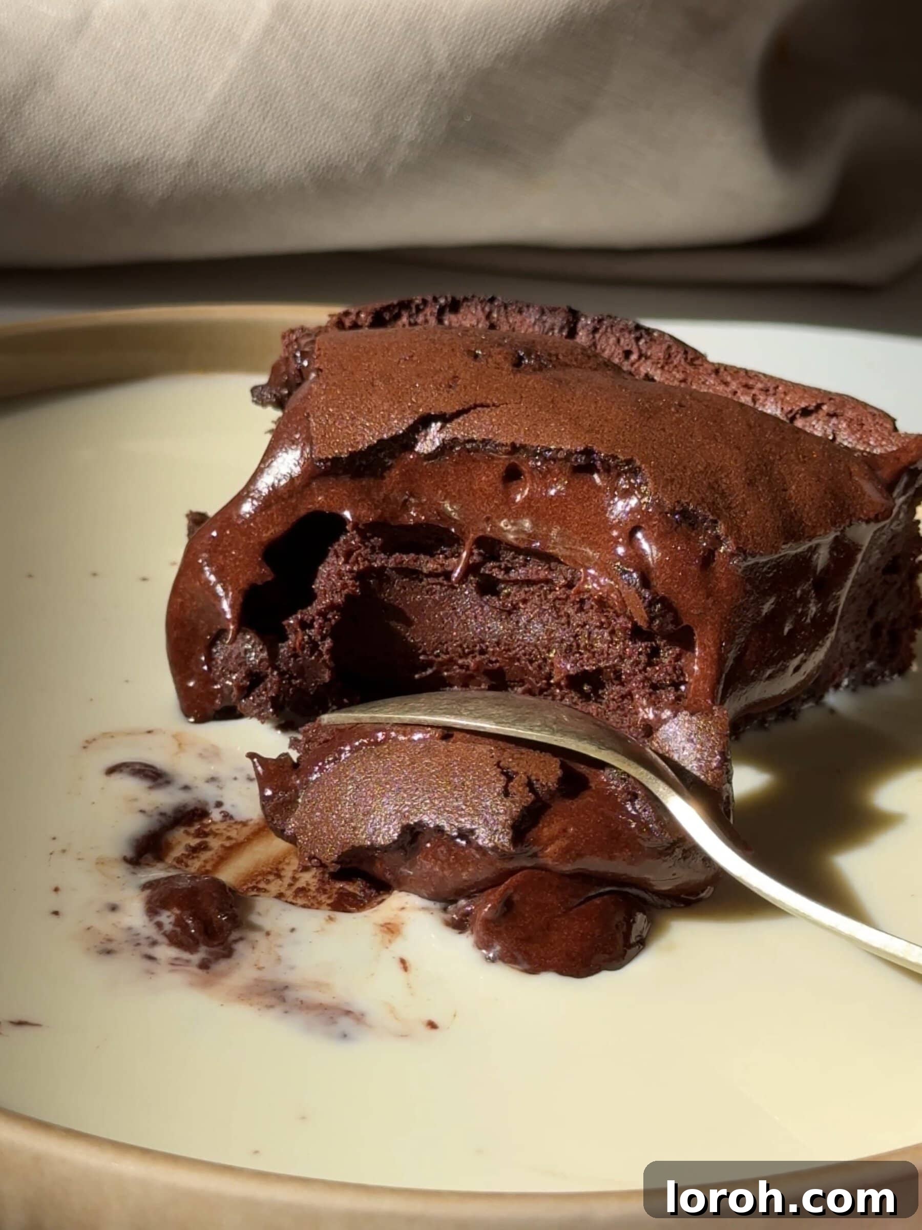 Slice of Moelleux au Chocolat with a gooey, molten center, served with fresh raspberries.