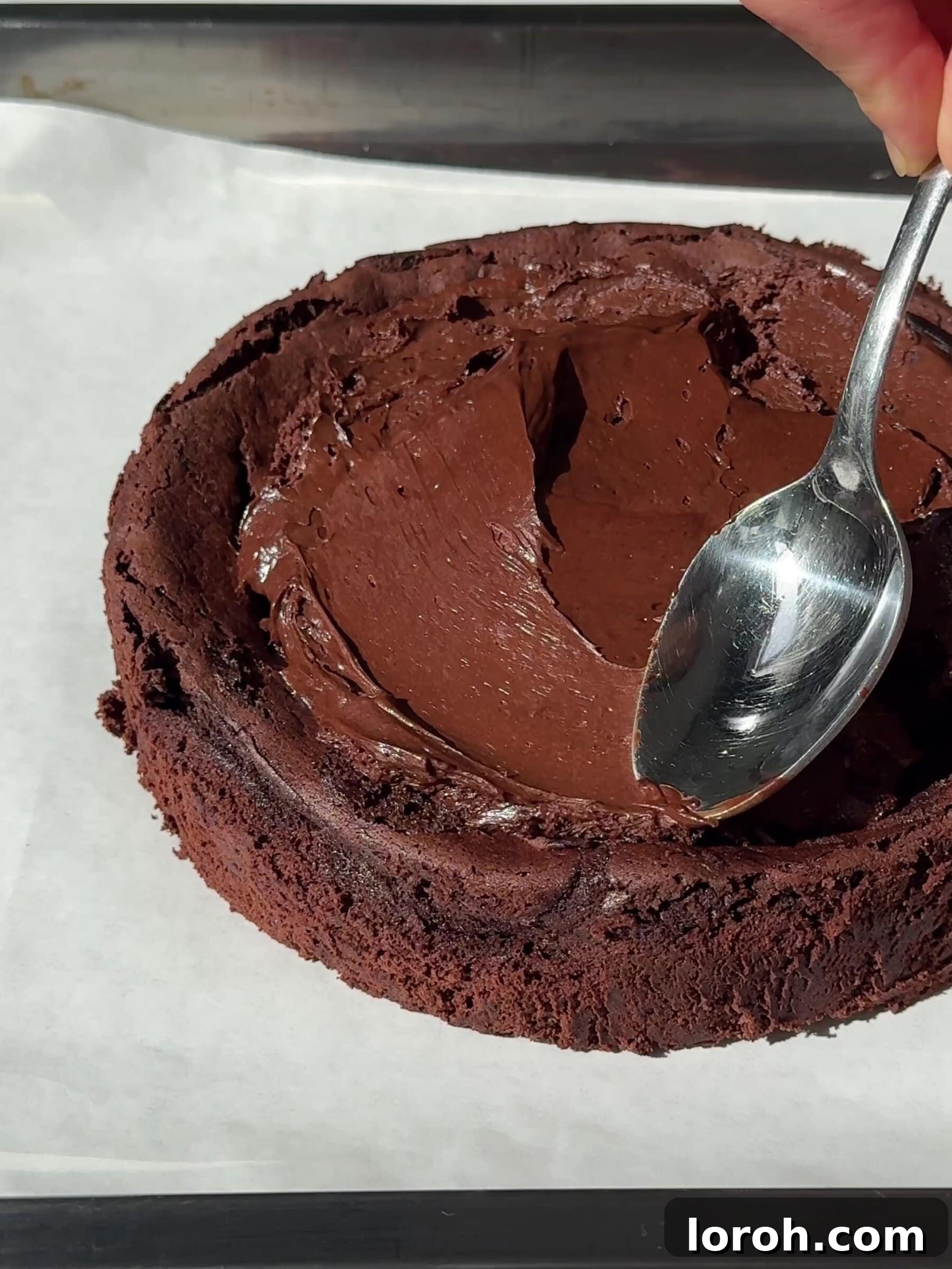 Spreading the chilled Moelleux au Chocolat batter onto the cooled baked cake layer.