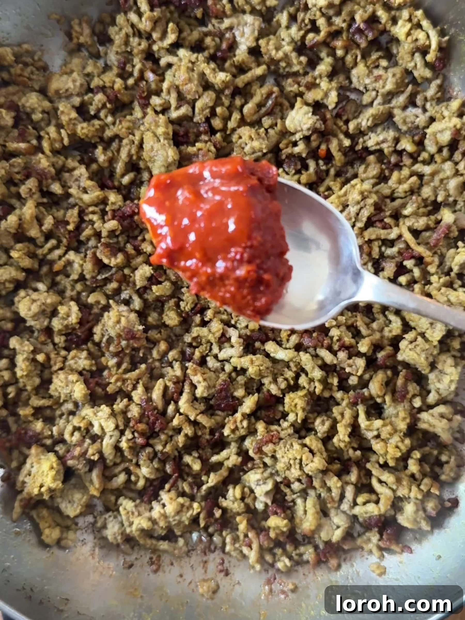 Golden Lamb & Couscous with Bright Herb Salad 6 Harissa paste being stirred into the crispy lamb mince.